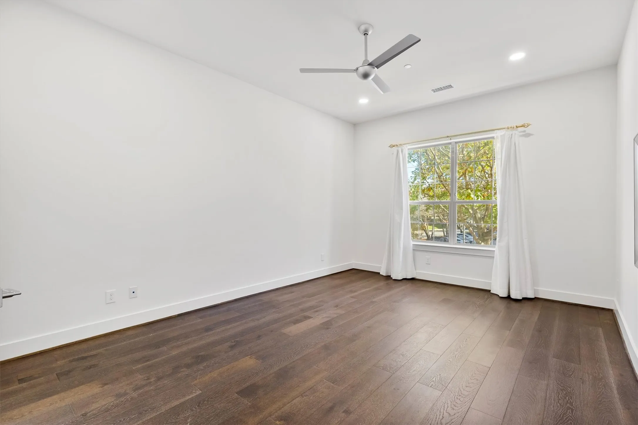 Empty room with dark wood finished floors, recessed lighting, and ceiling fan