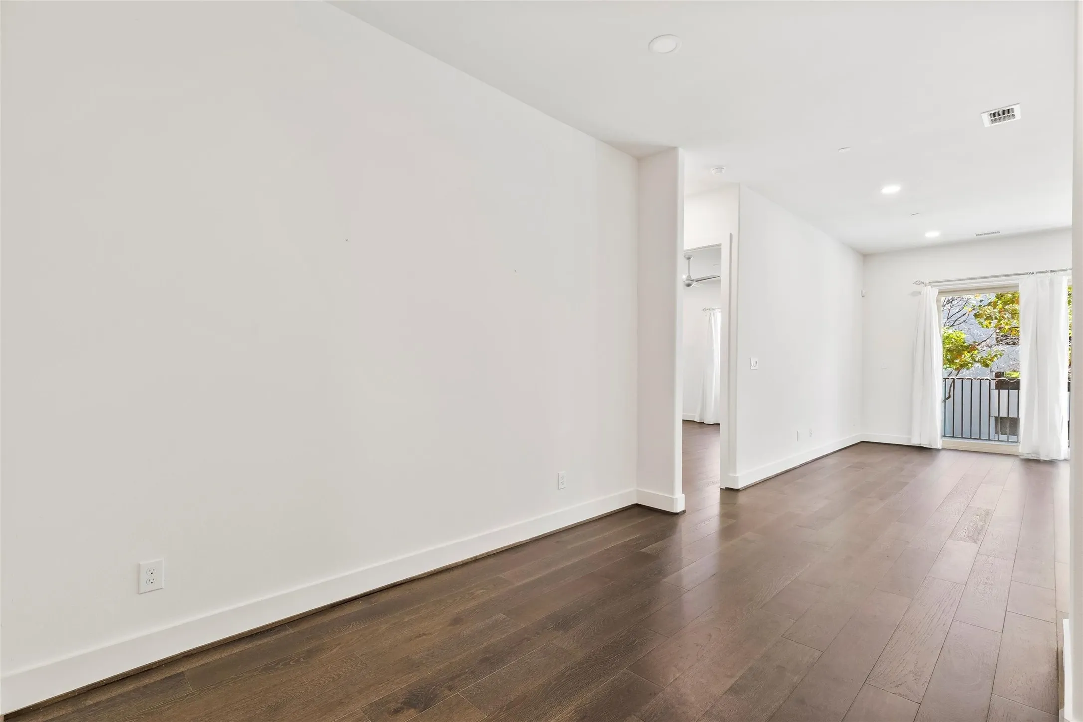 Empty room with dark wood finished floors and recessed lighting