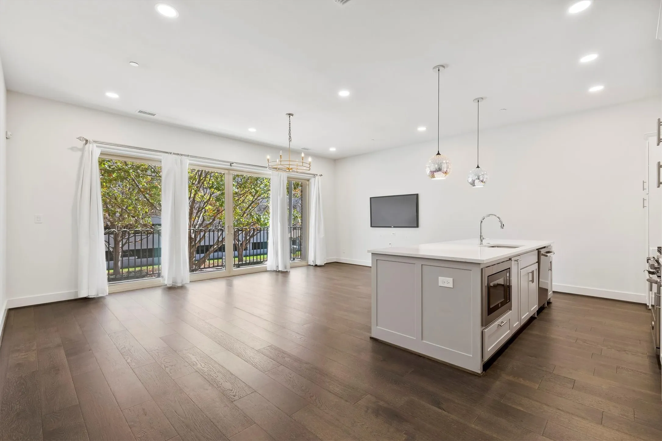 Kitchen opens to living room with view overlooking the balcony