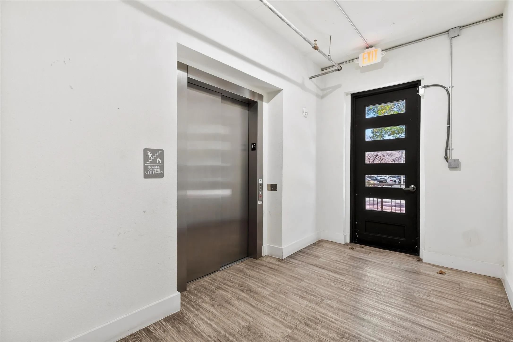 Common area Foyer with elevator and light wood finished floors