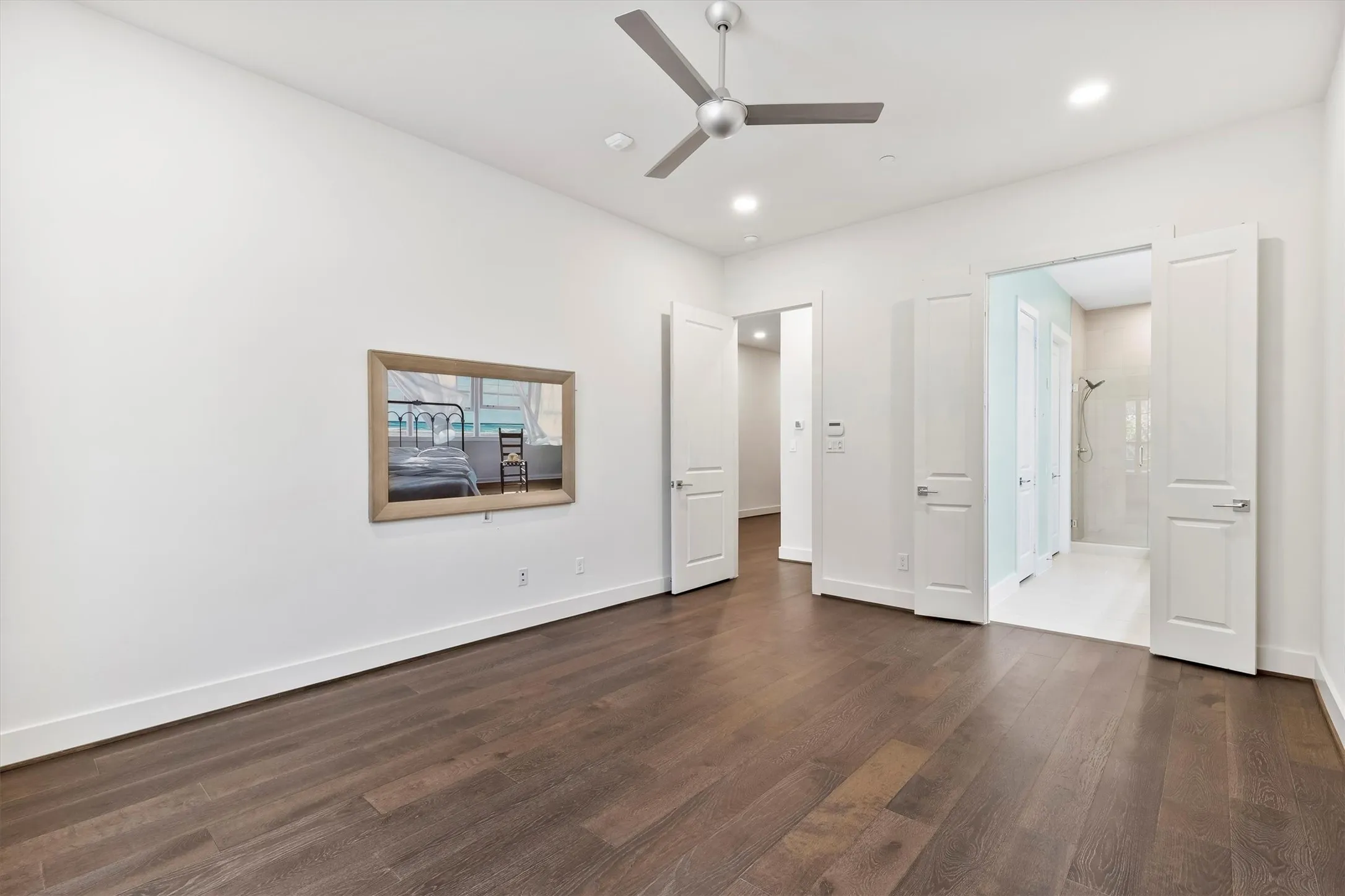 Unfurnished bedroom with dark wood flooring, ceiling fan, connected bathroom, and recessed lighting