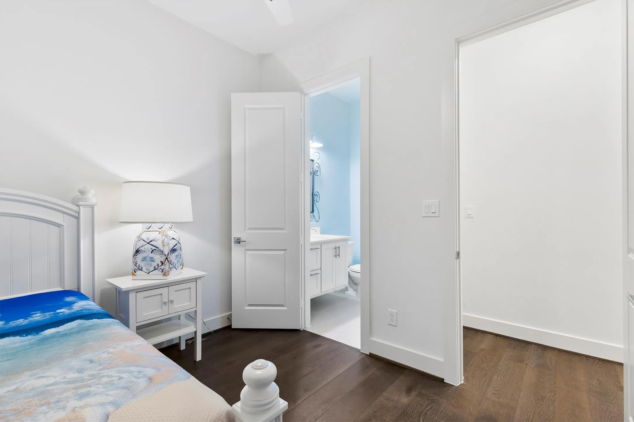 Bedroom with dark wood finished floors and ensuite bathroom. *staged to show potential*