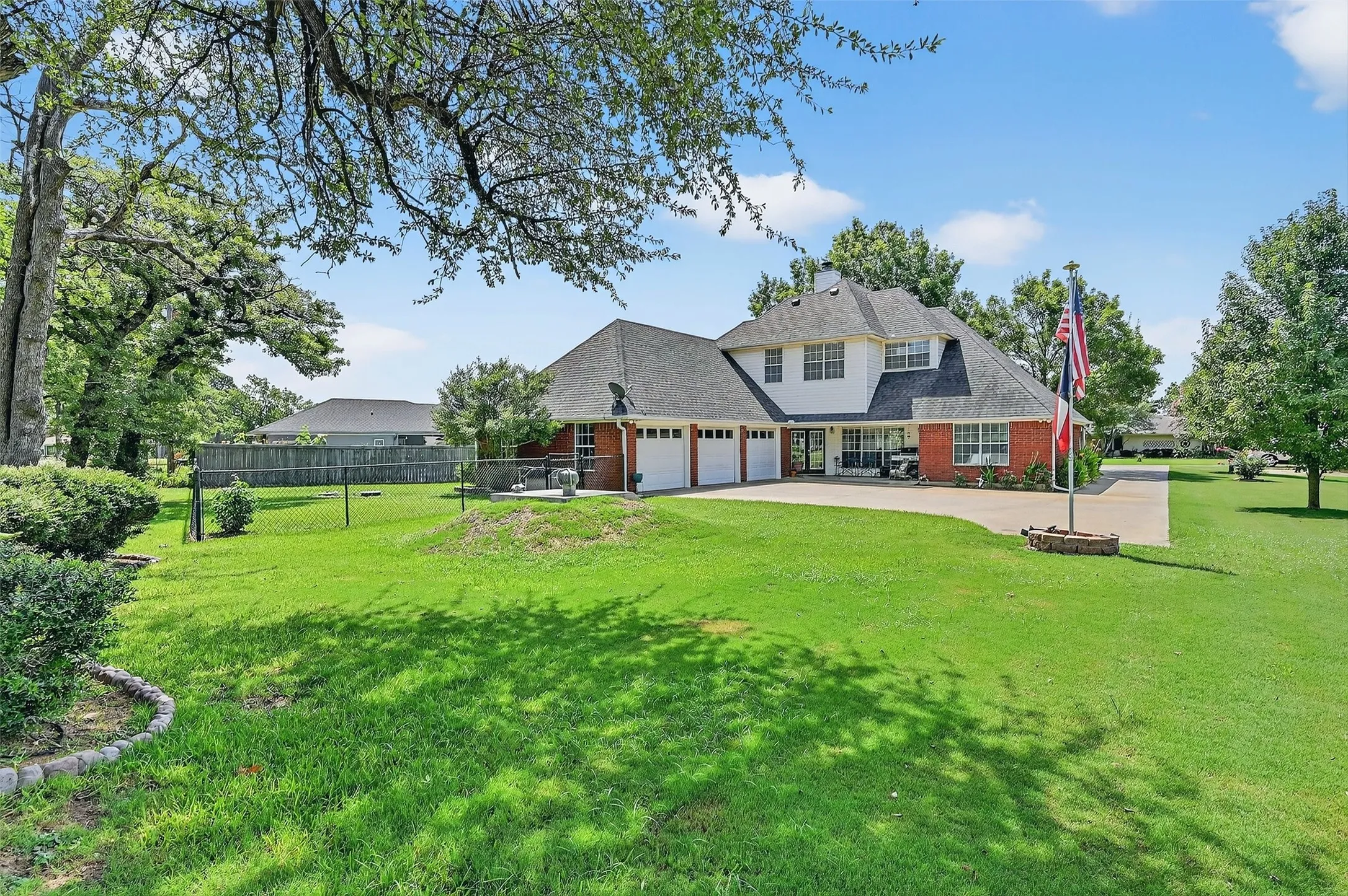 Rear view of property featuring concrete driveway, a garage, brick siding, and roof with shingles