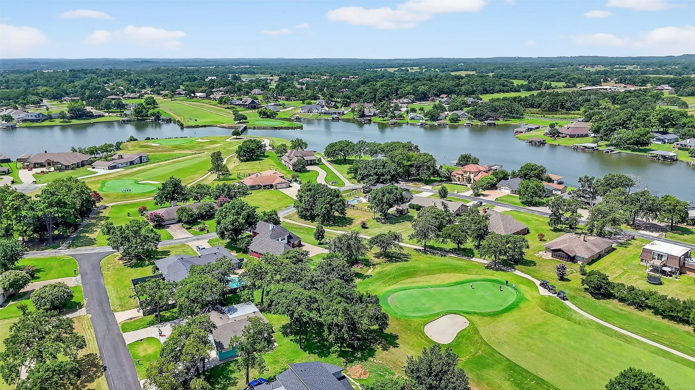 Aerial perspective of suburban area featuring a large body of water and a local golf course