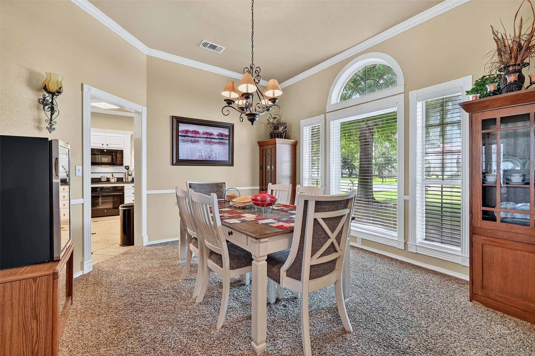 Dining space featuring ornamental molding, a chandelier, and light colored carpet
