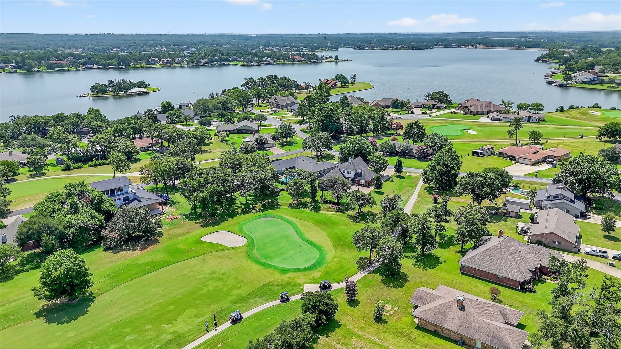 Aerial perspective of suburban area with a large body of water and a local golf course