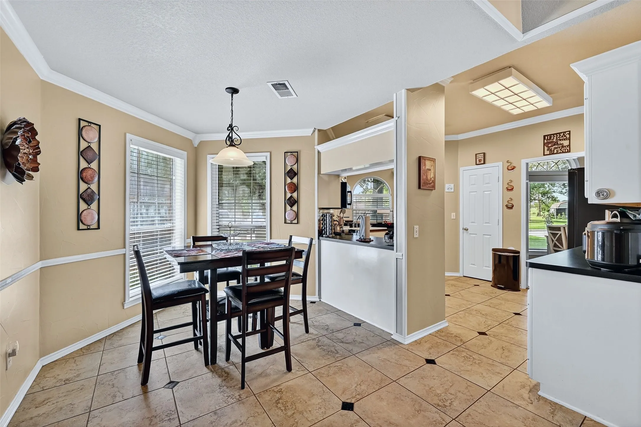 Dining room featuring crown molding and light tile patterned flooring