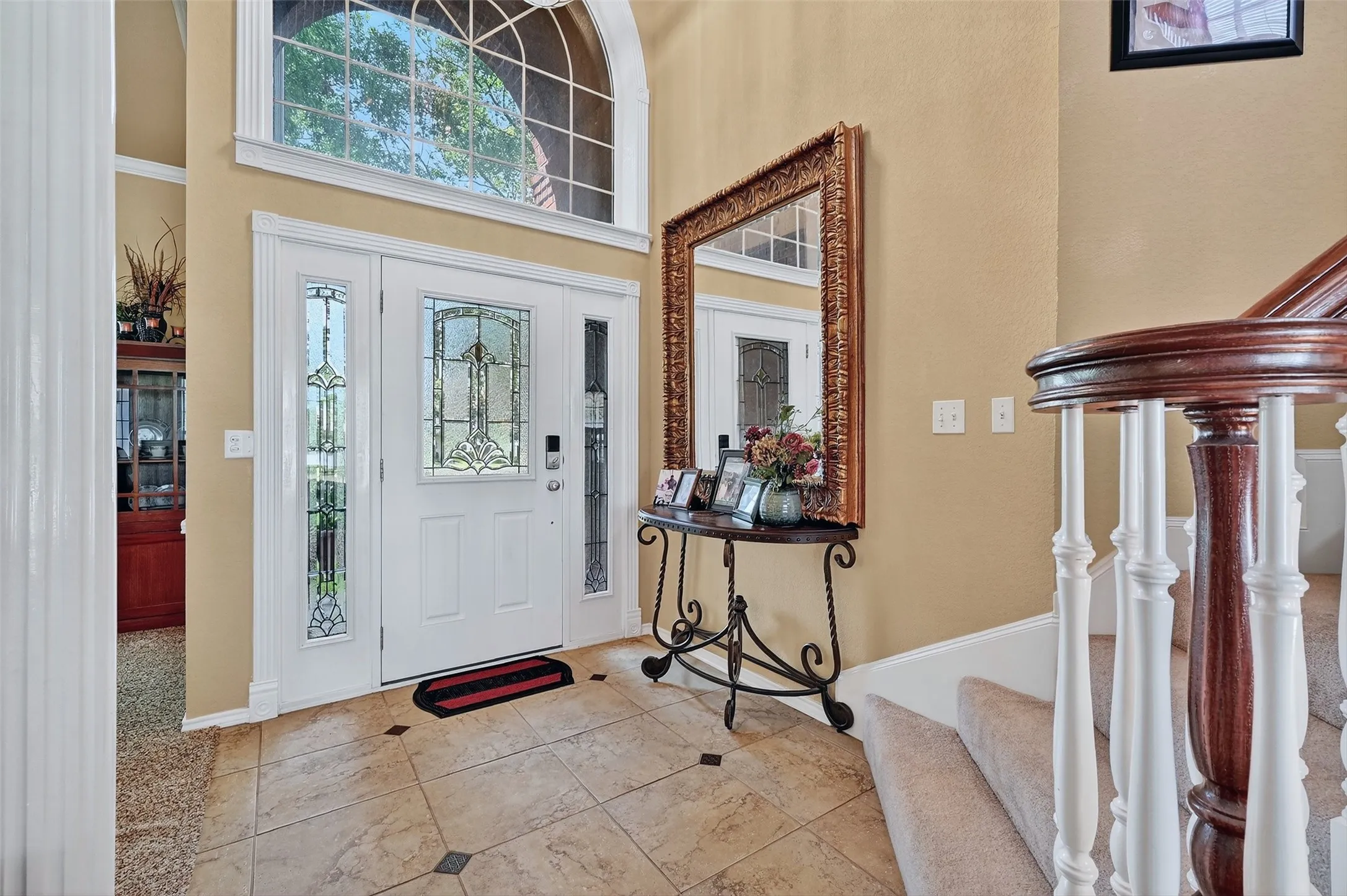Foyer entrance featuring a towering ceiling, stairs, and tile patterned floors
