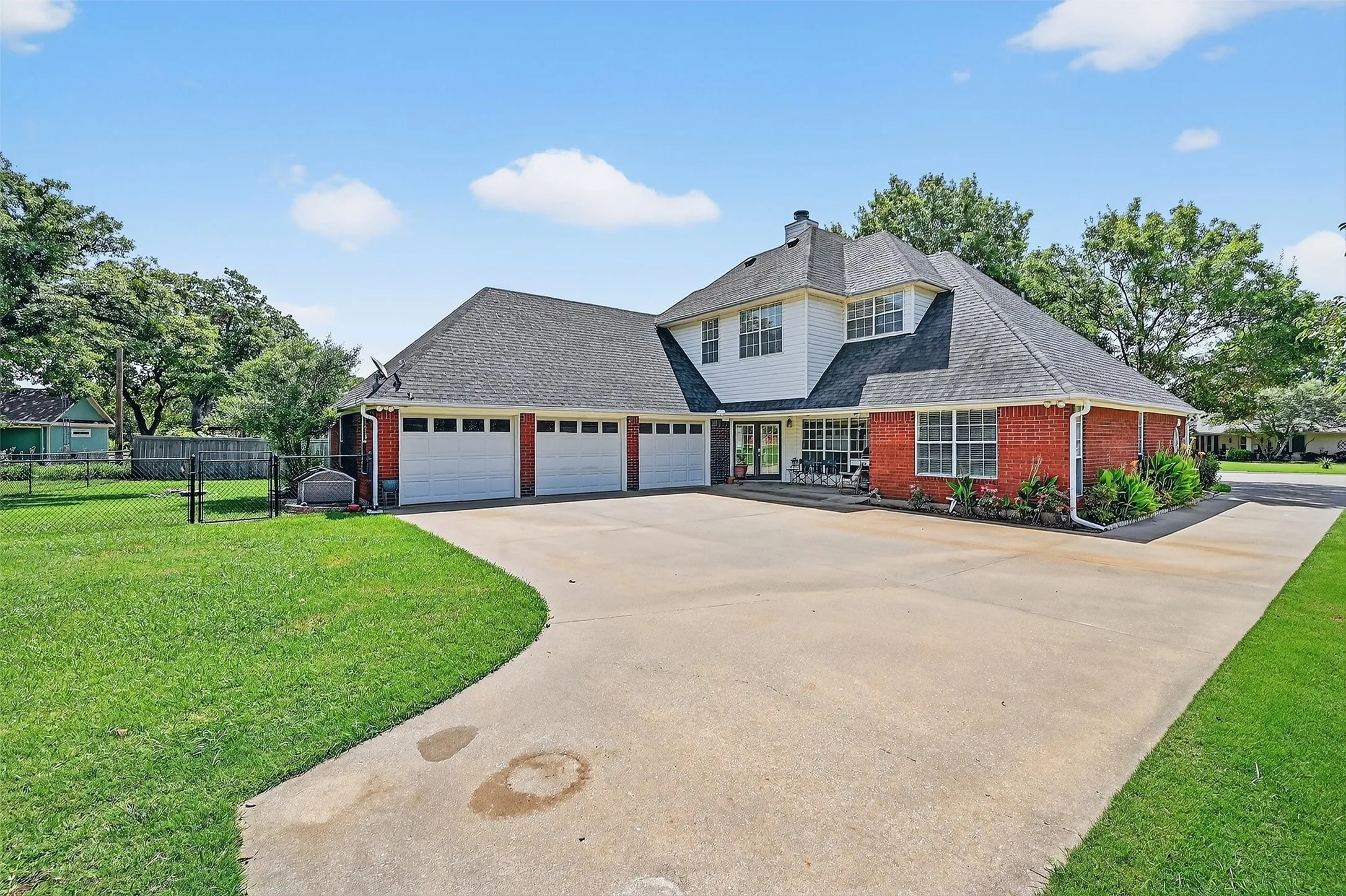 View of front of home featuring a shingled roof, driveway, brick siding, a garage, and a chimney