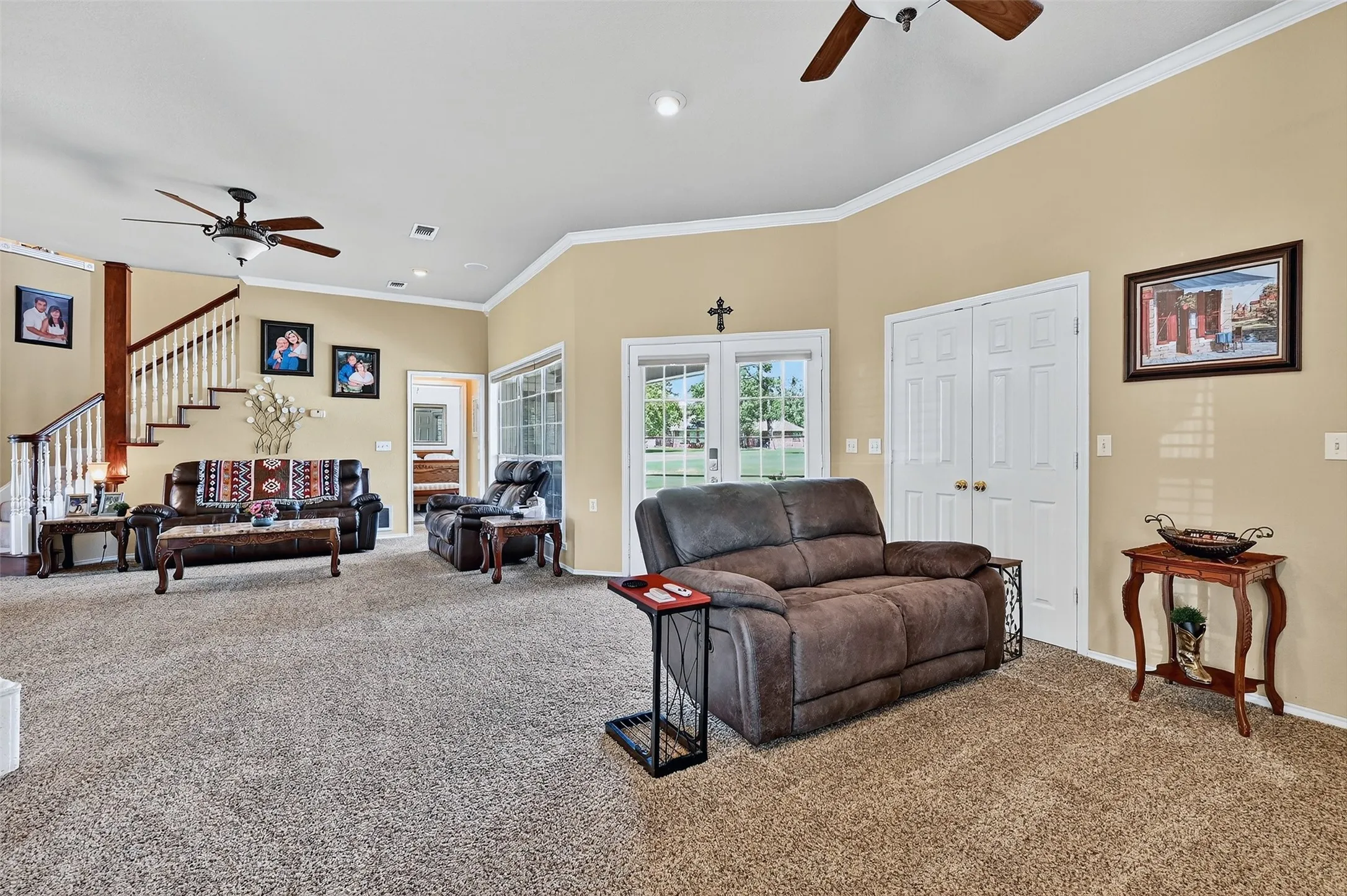 Carpeted living area featuring a ceiling fan, ornamental molding, stairway, and recessed lighting