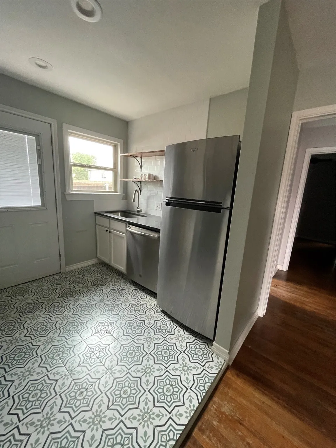 Kitchen with refrigerator, dishwashing machine, and light wood-style floors