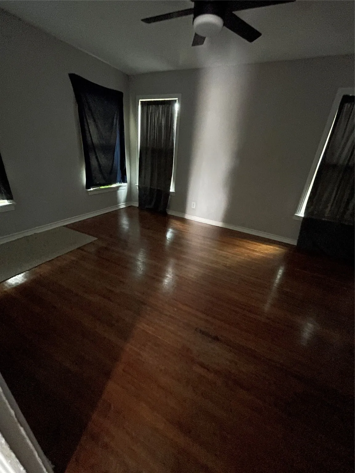 Spare room with wood finished floors and a ceiling fan