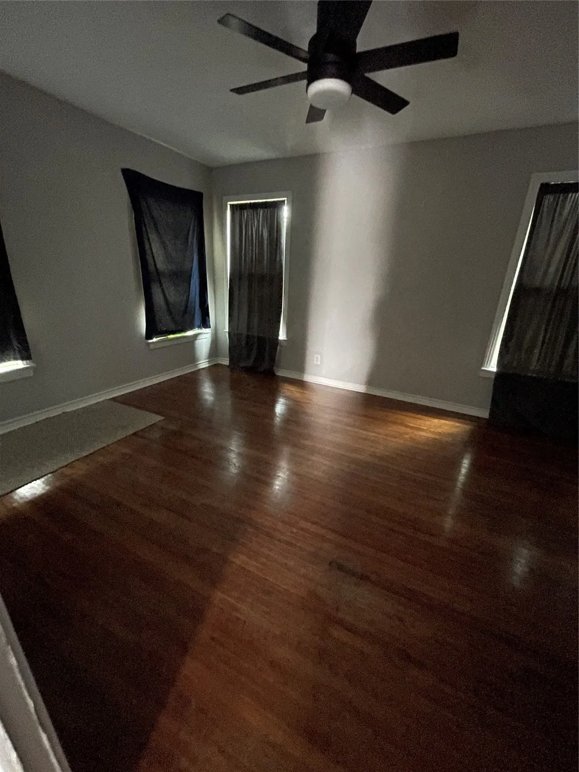 Spare room with wood finished floors and a ceiling fan