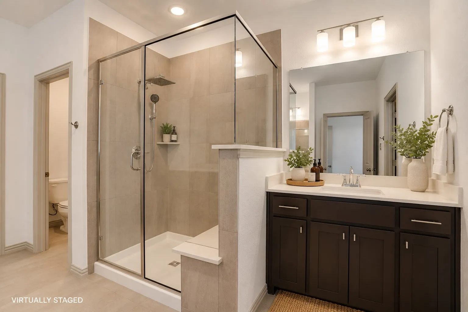 Glass-enclosed shower with a rainfall showerhead and handheld sprayer, complemented by a built-in shelf