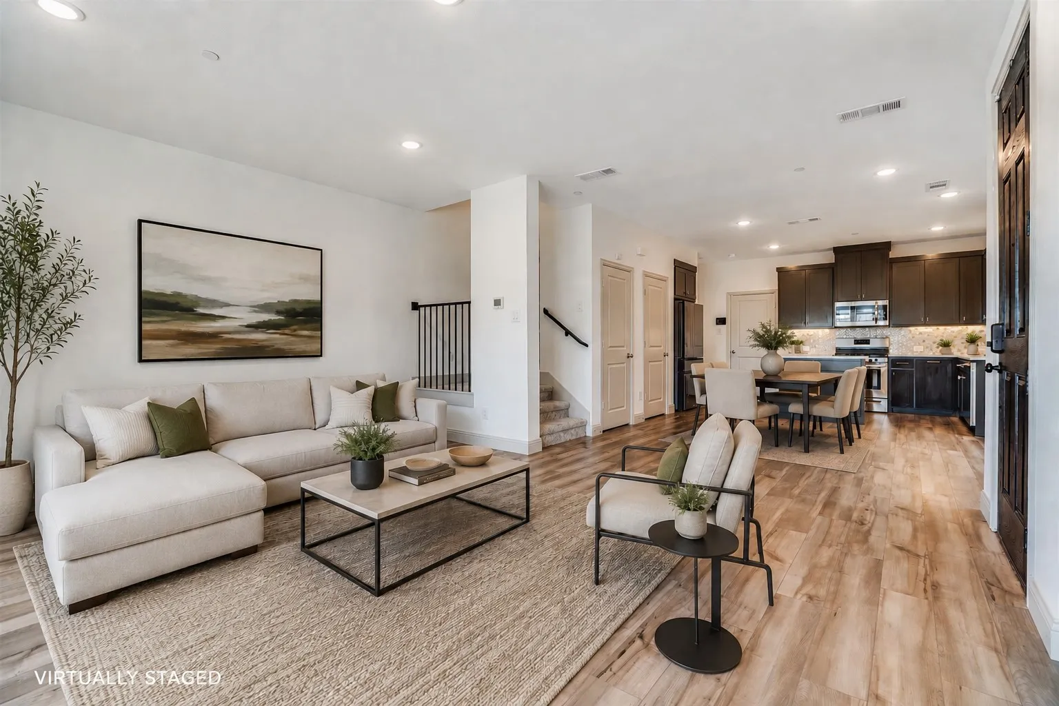Open-concept living space featuring wood-finish flooring, recessed lighting, and a neutral color palette
