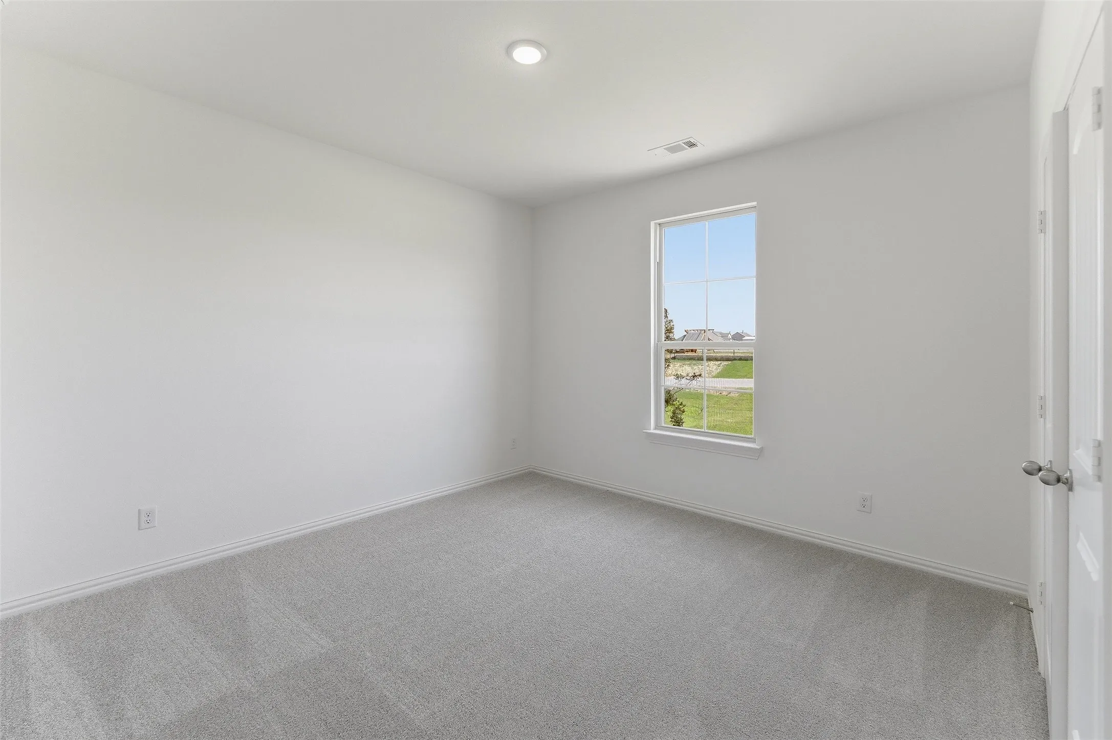 Bright interior room with plush grey carpeting and white walls