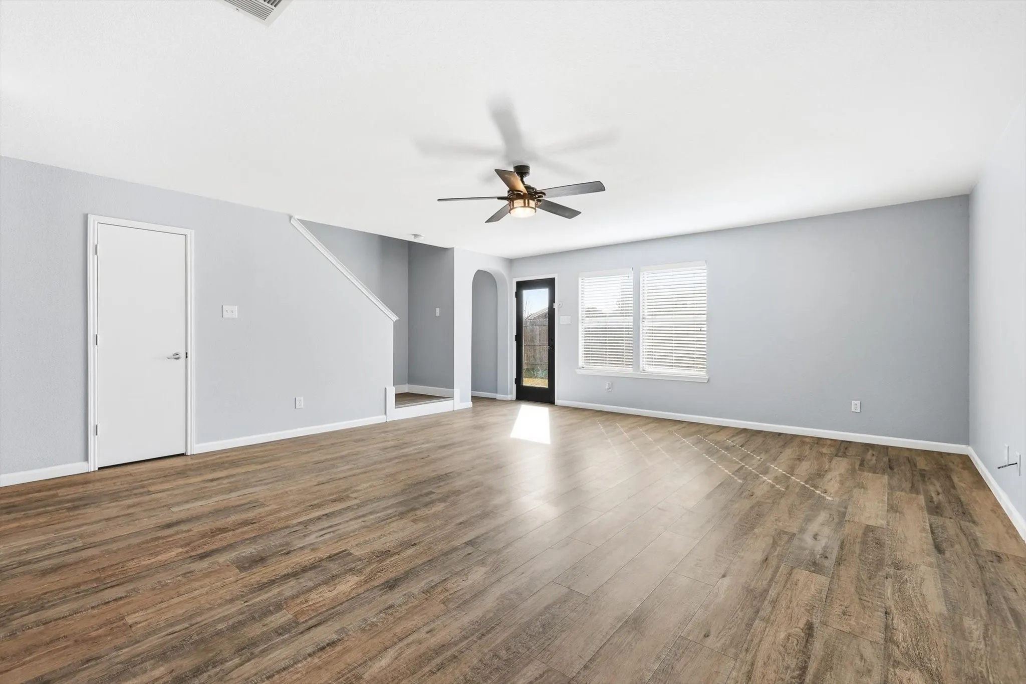 Unfurnished living room featuring light wood-style flooring, a ceiling fan, and recessed lighting