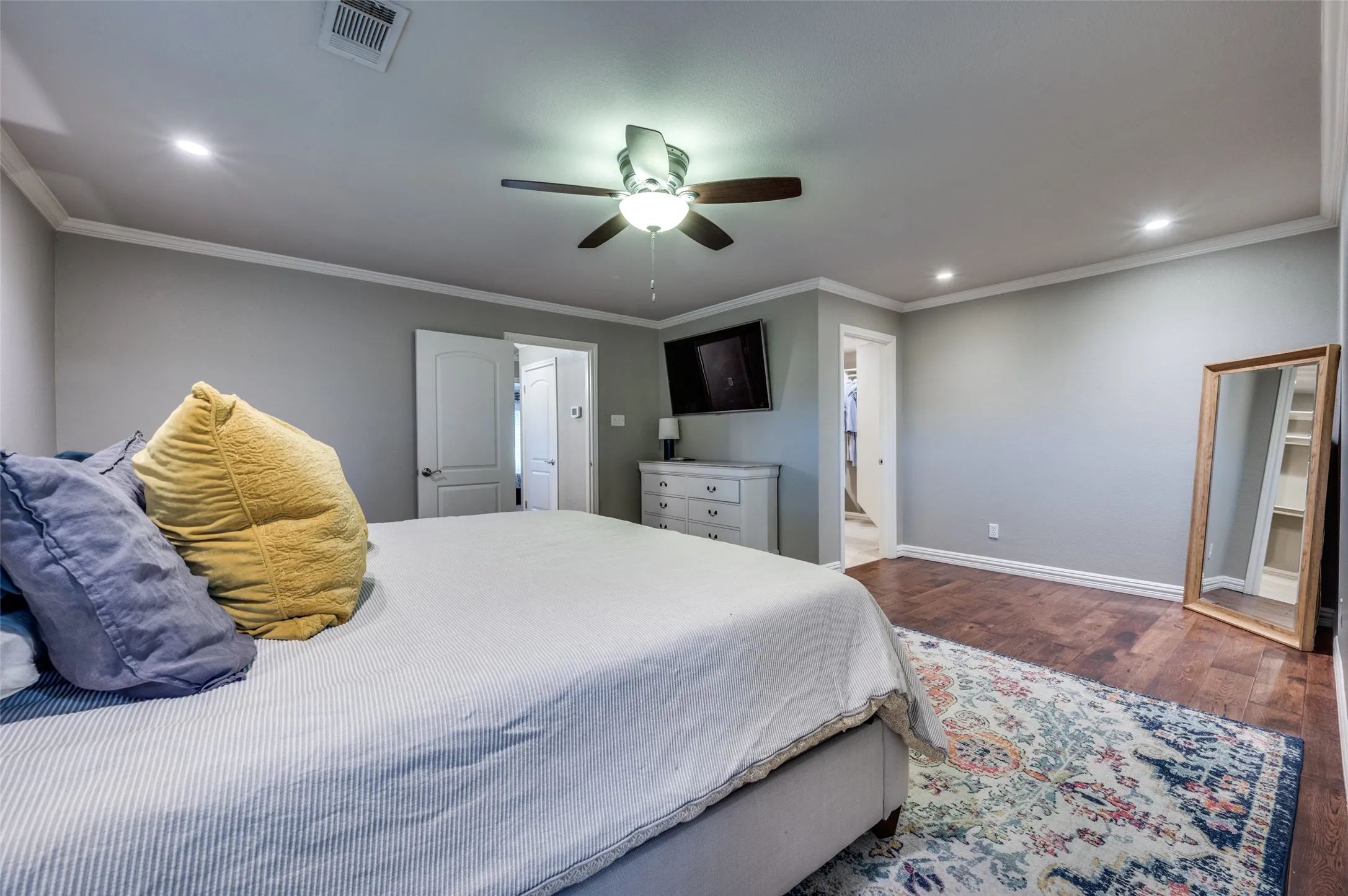 Bedroom with wood finished floors, recessed lighting, crown molding, a ceiling fan, and connected bathroom