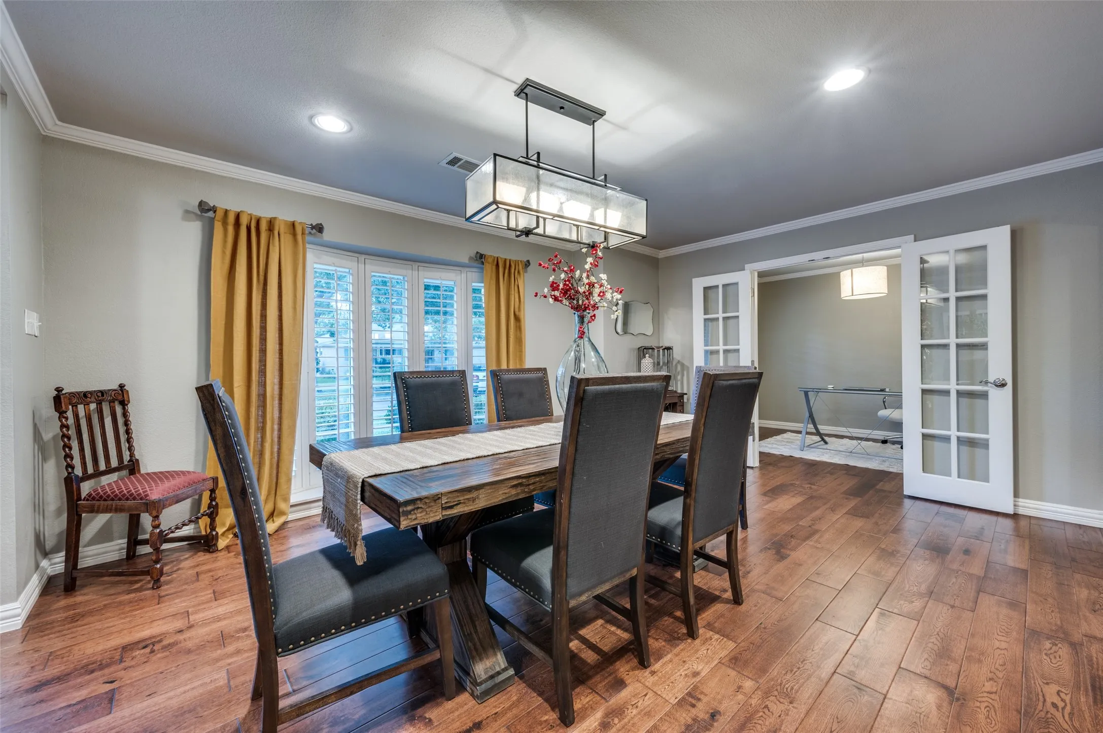 Dining room featuring french doors, dark wood-style floors, crown molding, recessed lighting, and a chandelier