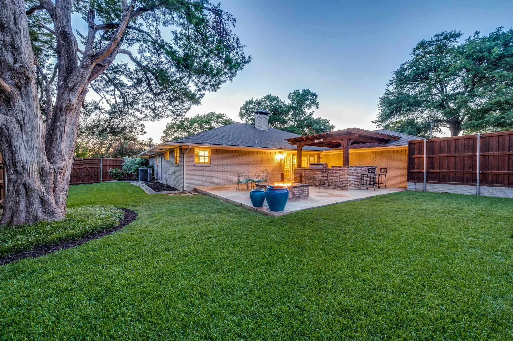 Back of house featuring a chimney, brick siding, a patio, a fenced backyard, and a pergola