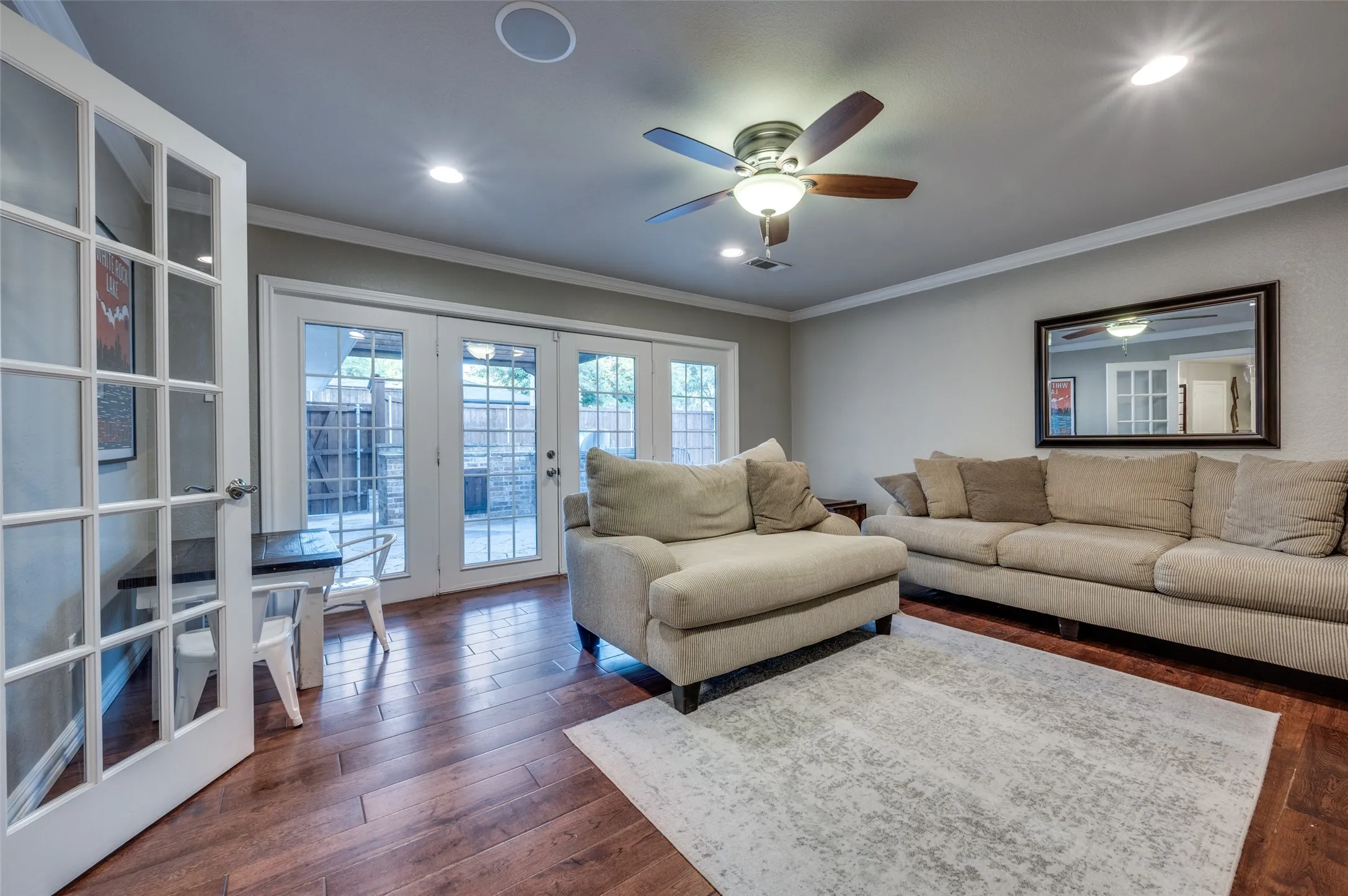 Living area featuring french doors, ornamental molding, dark wood finished floors, a ceiling fan, and recessed lighting