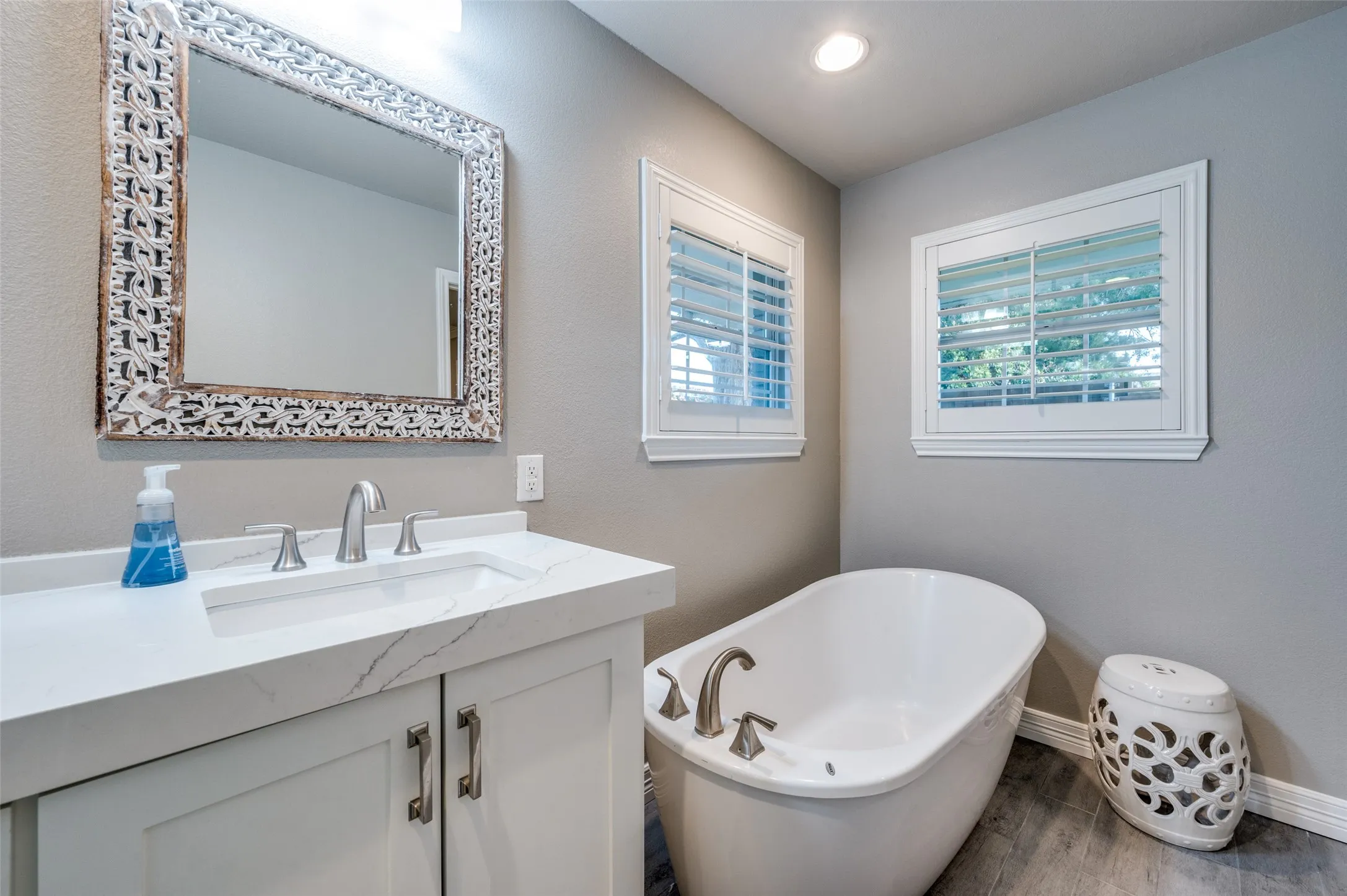 Bathroom with a soaking tub, vanity, and wood finished floors