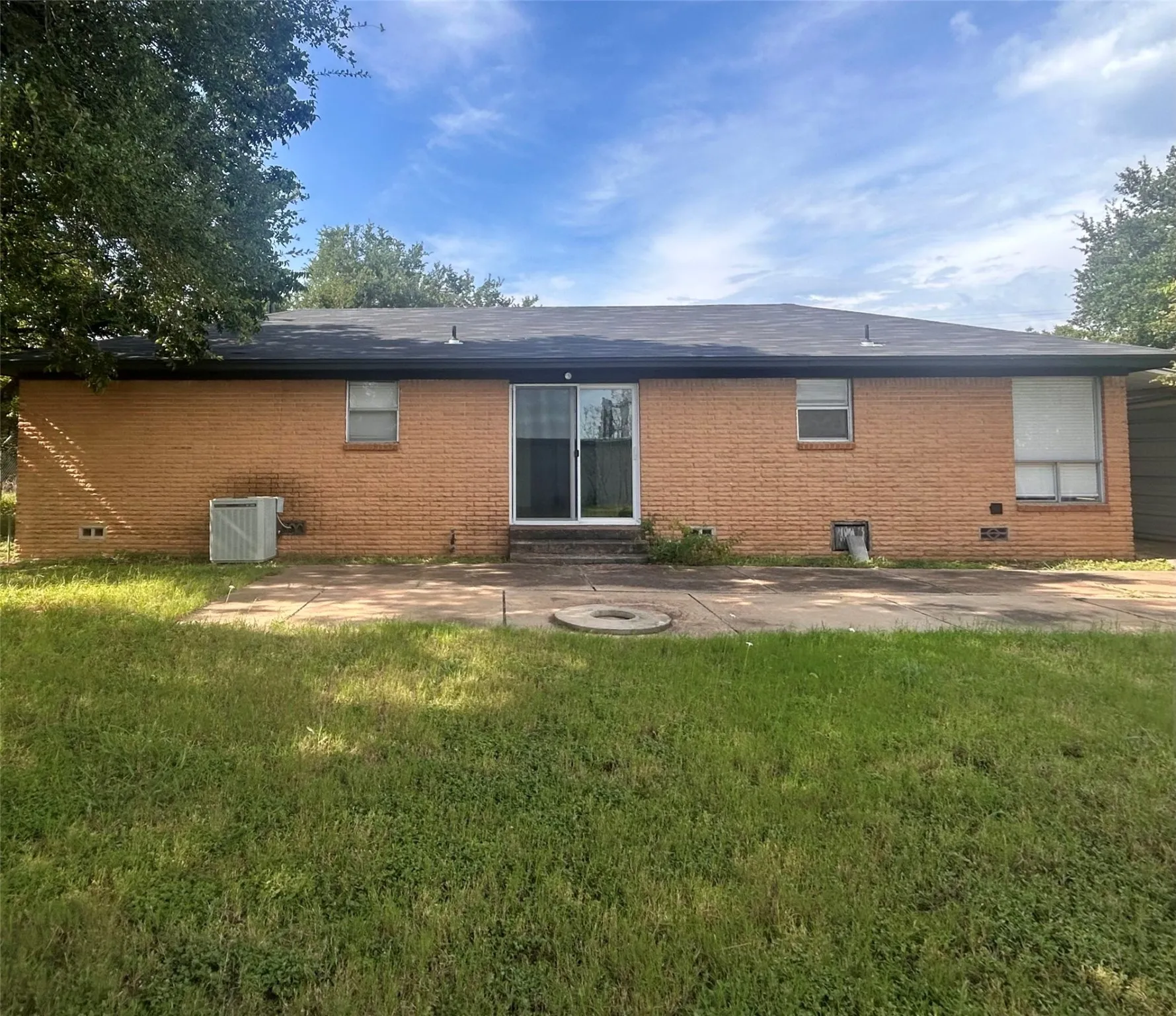 Back of house featuring a patio area, brick siding, and a yard