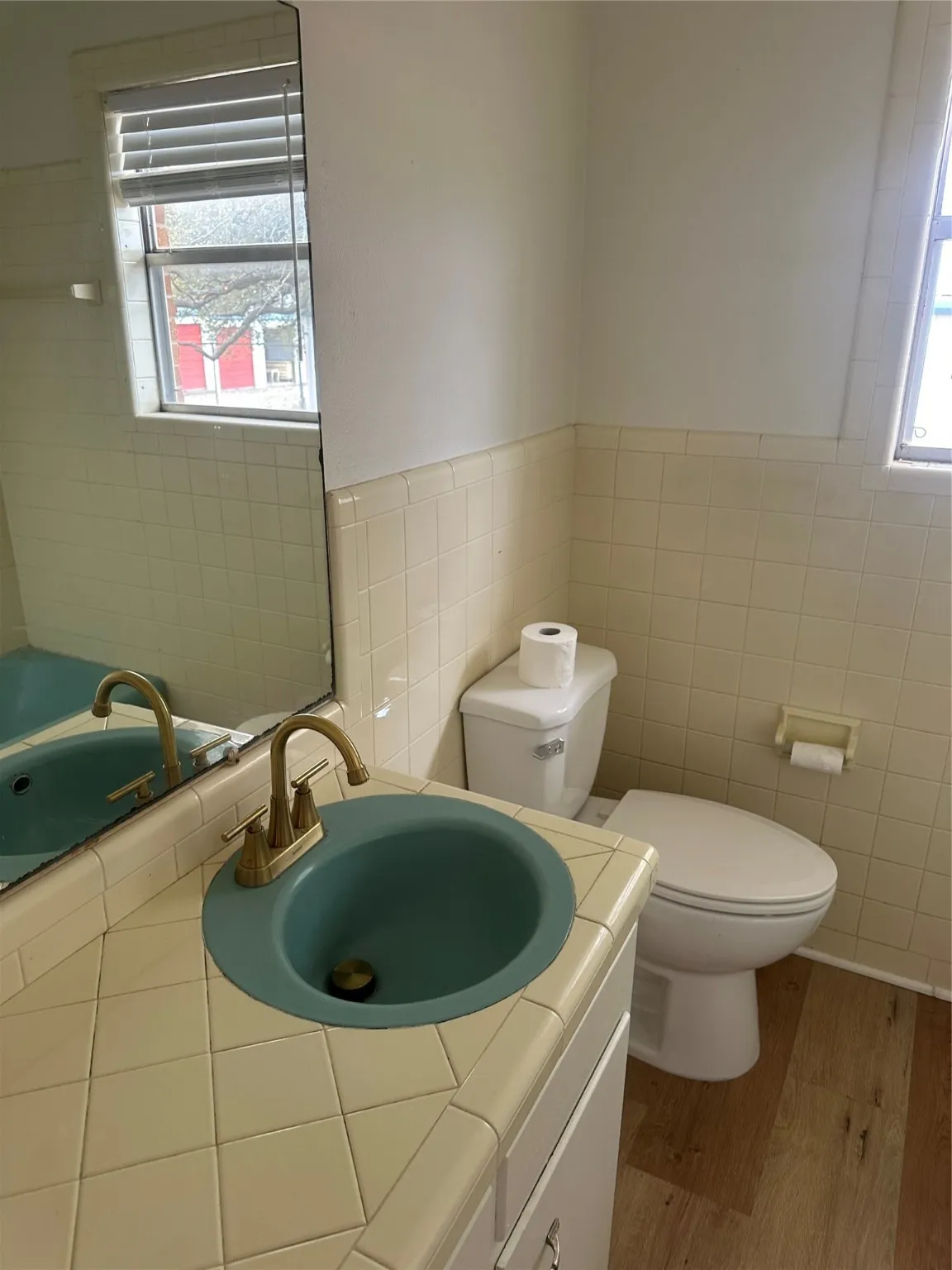 Bathroom featuring tile walls, vanity, and wainscoting
