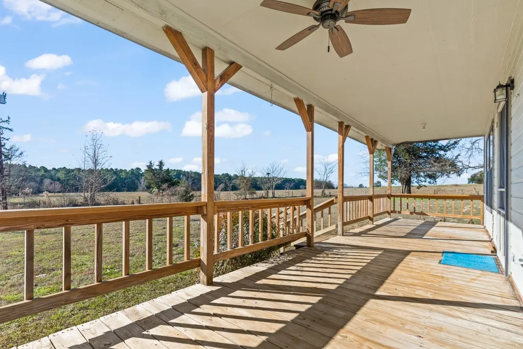 Wooden terrace featuring a ceiling fan