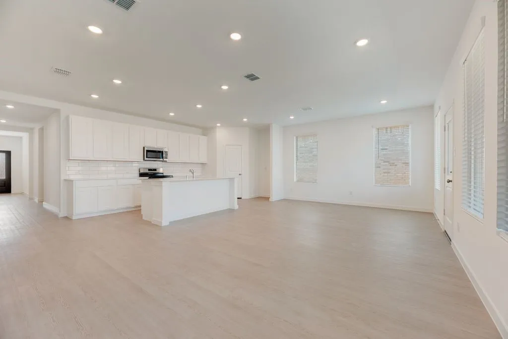 Unfurnished living room with light wood-type flooring and recessed lighting