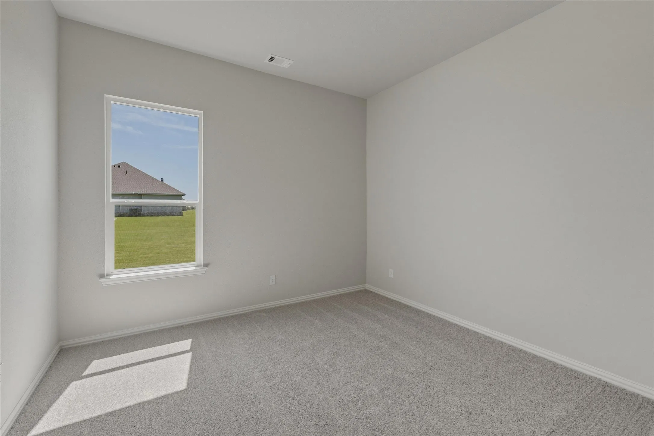Carpeted interior room with light grey walls and white trim