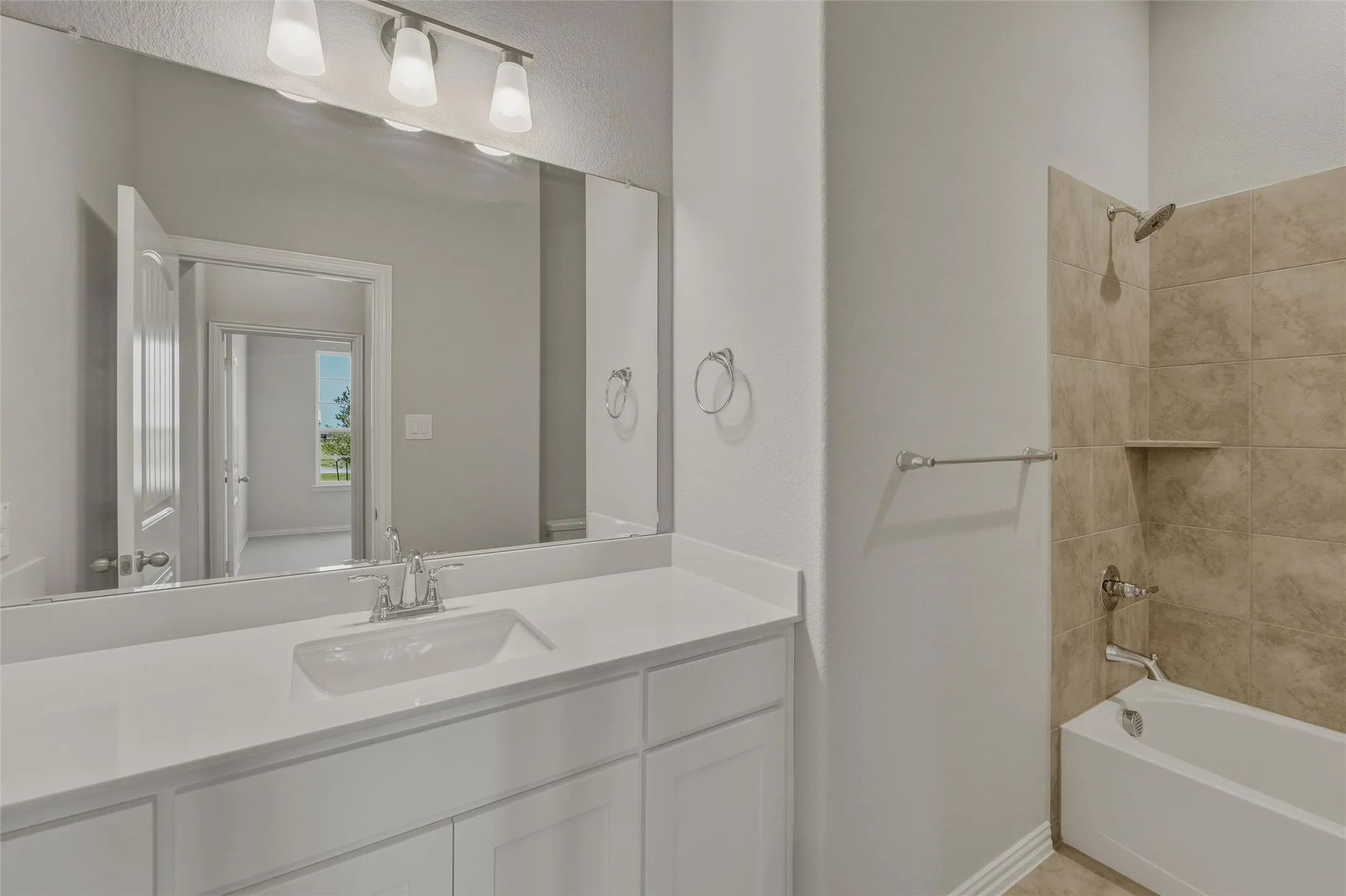 Bathroom featuring a single vanity with a white countertop and undermount sink, chrome faucet, and a large wall-mounted mirror