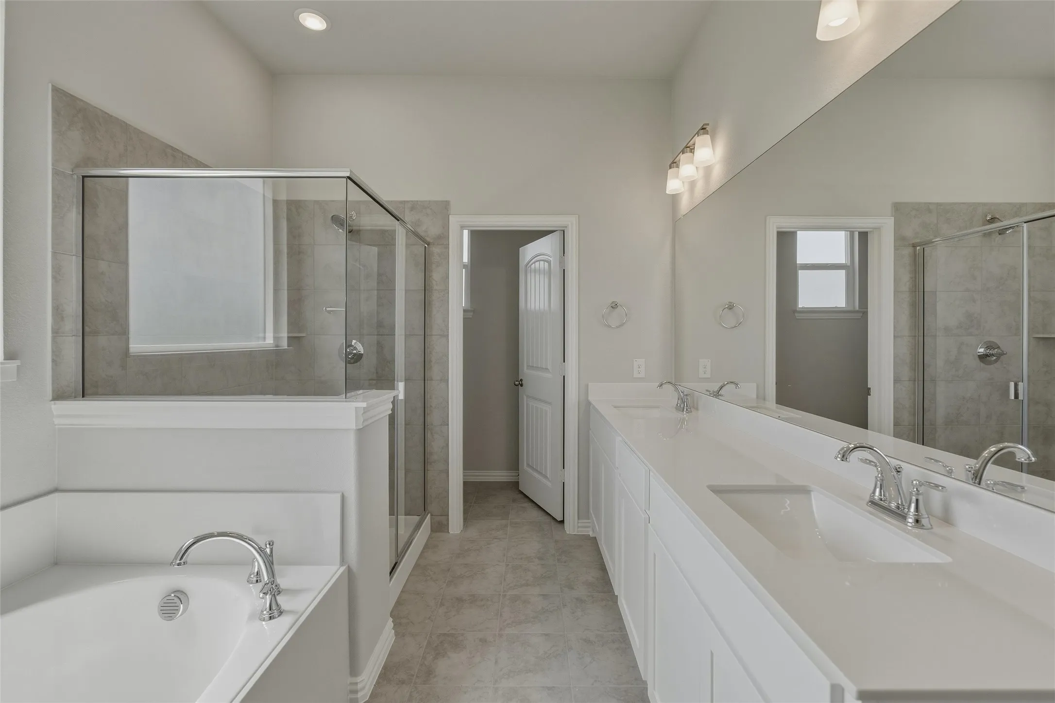 Contemporary bathroom featuring a spacious walk-in shower with glass enclosure, a built-in soaking tub, and a double vanity with undermount sinks