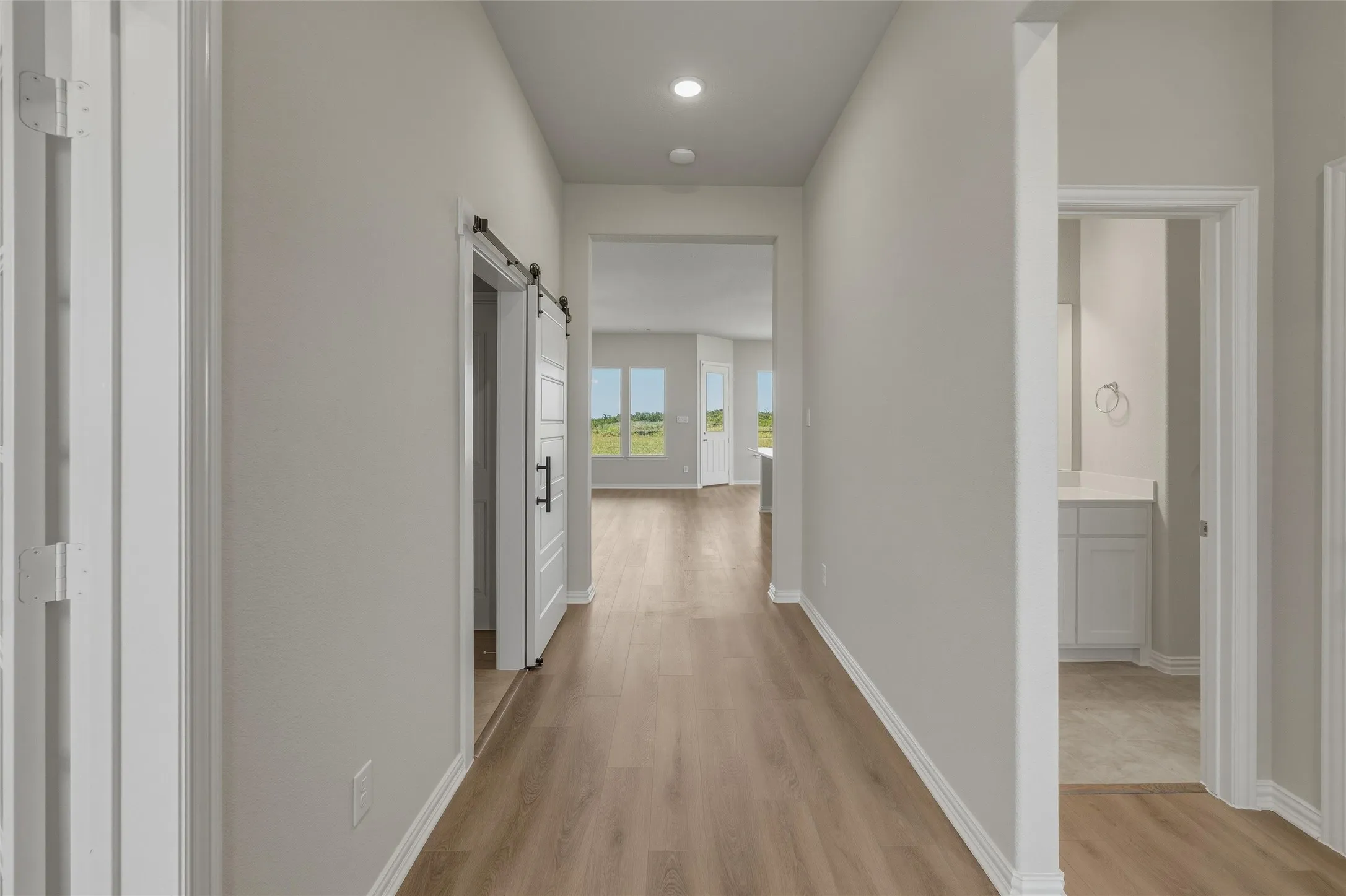 Inviting hallway with wood-finish flooring and recessed lighting