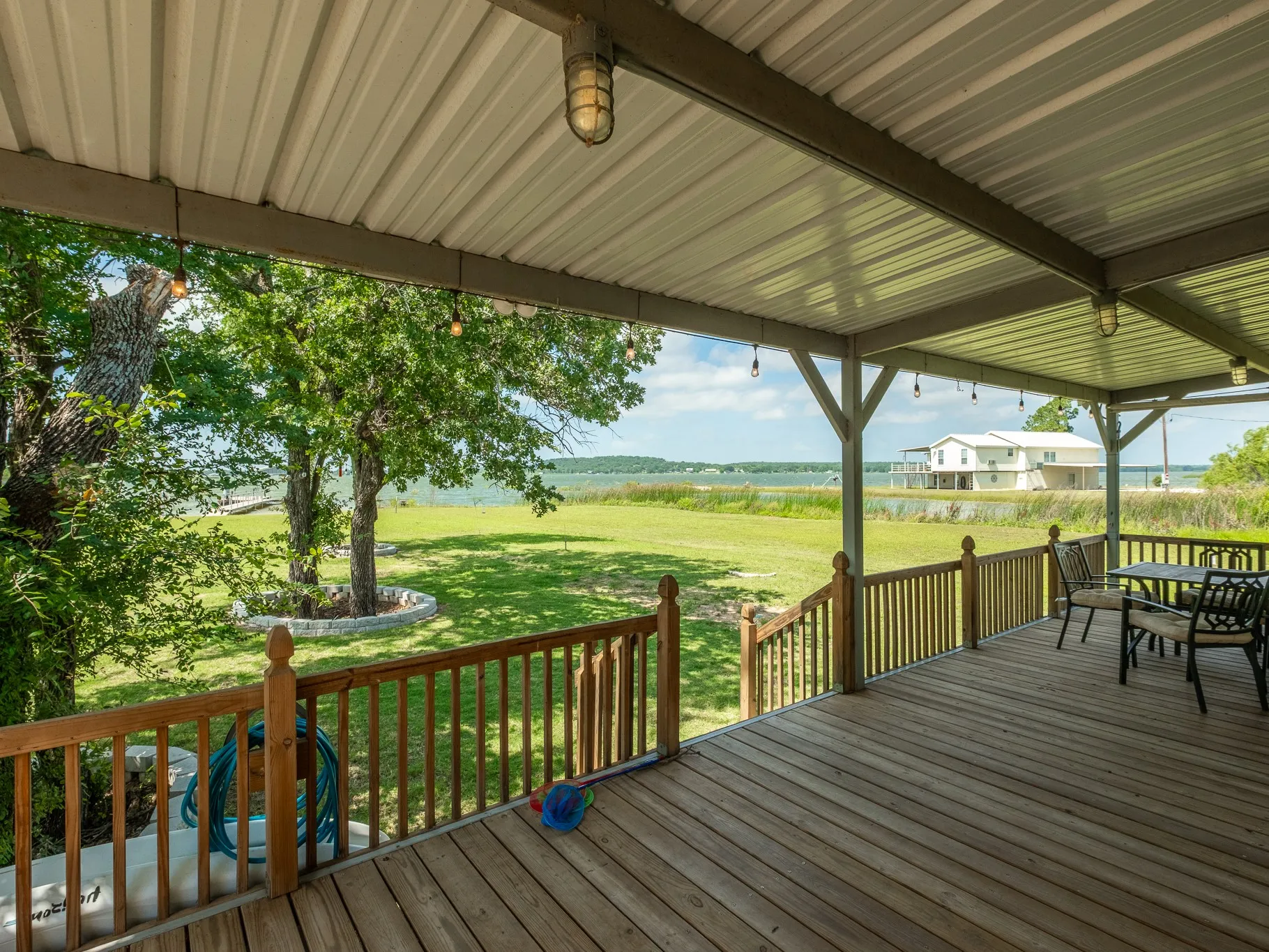 Extensive covered porch looking out at the private dock, boat ramp and lke frontage #lakefront #boatramp #dock #coveredporch #lakeleon #lakecabin