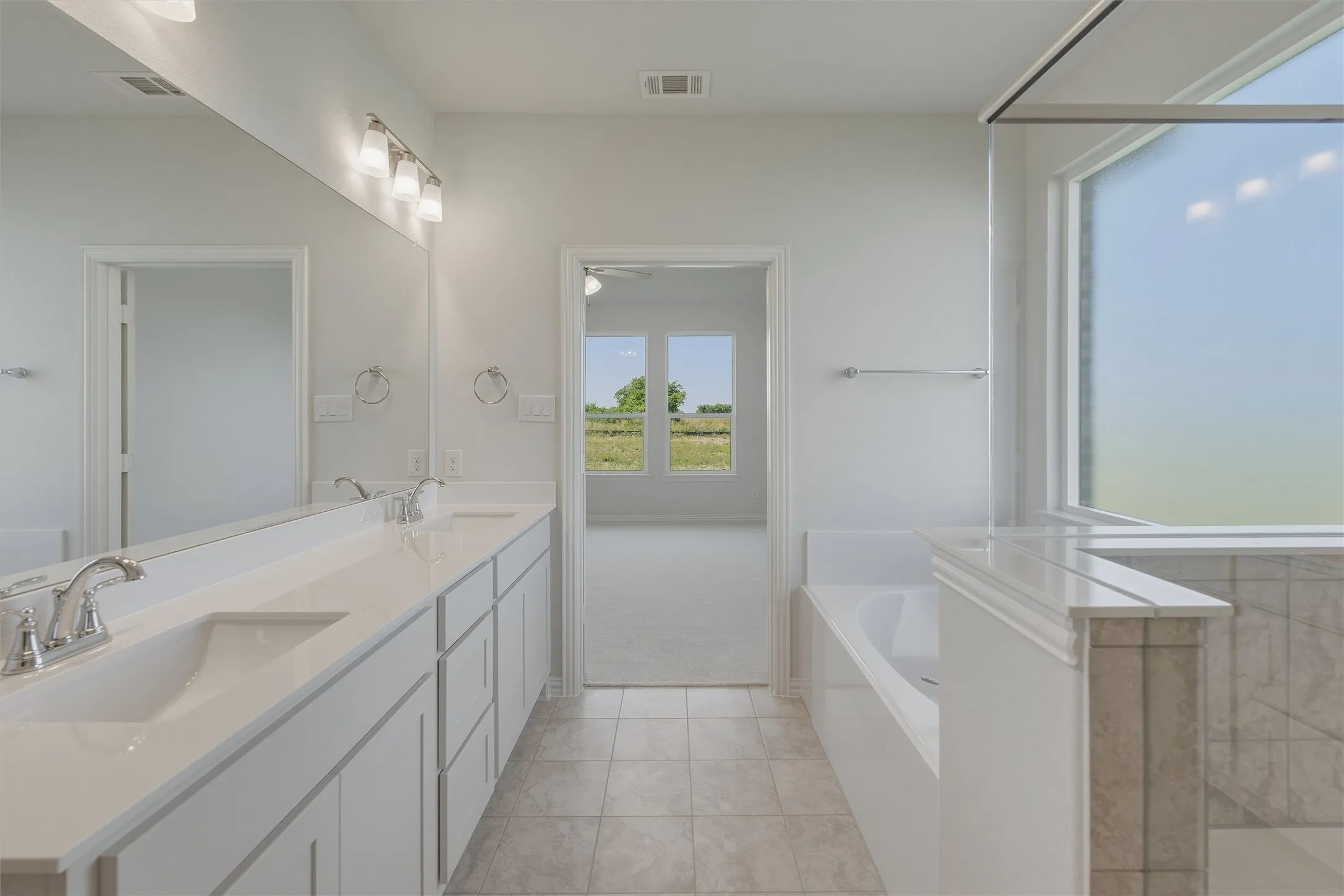 Contemporary bathroom featuring a double vanity with integrated sinks, white cabinetry, and brushed nickel hardware