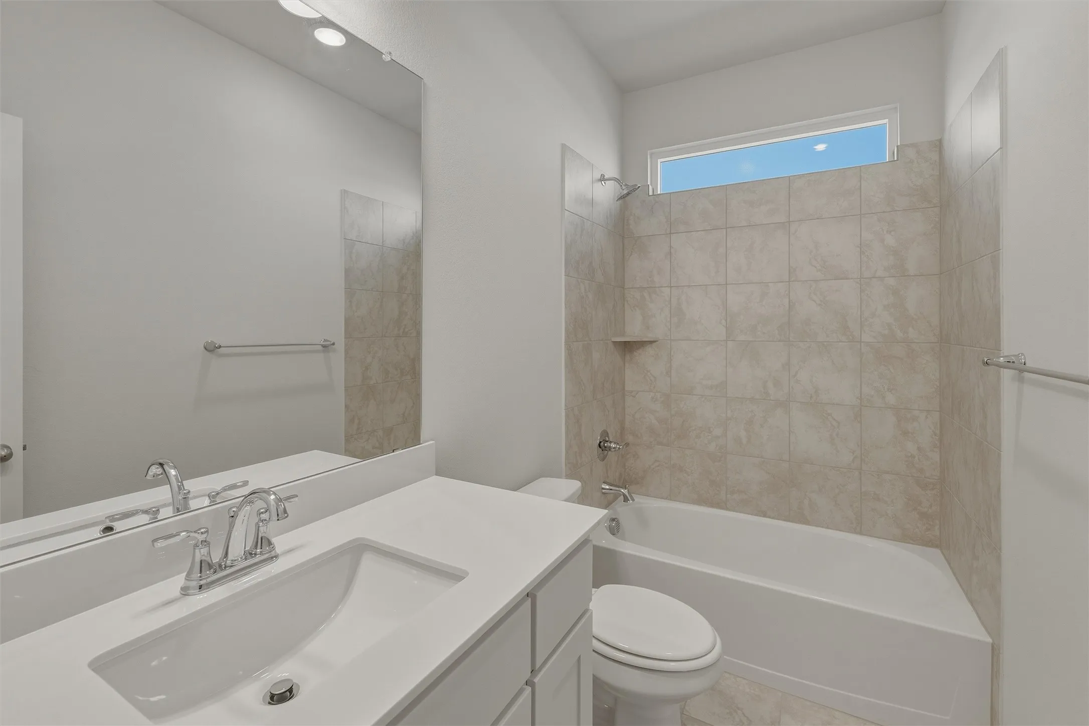 Bathroom featuring a vanity with an integrated sink, polished chrome faucet, and expansive mirror