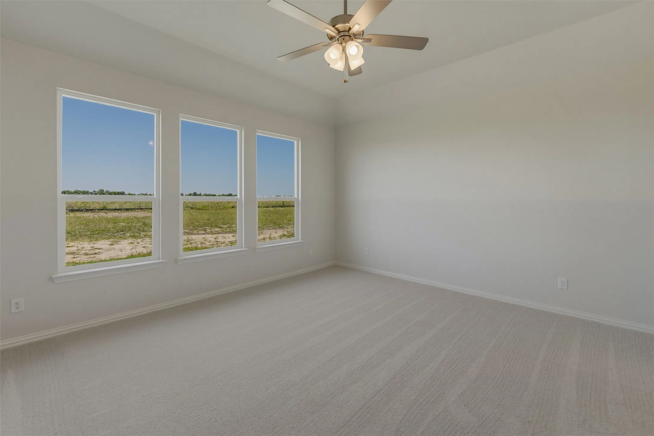 Spacious room featuring three large windows, light neutral wall paint, and plush carpet flooring