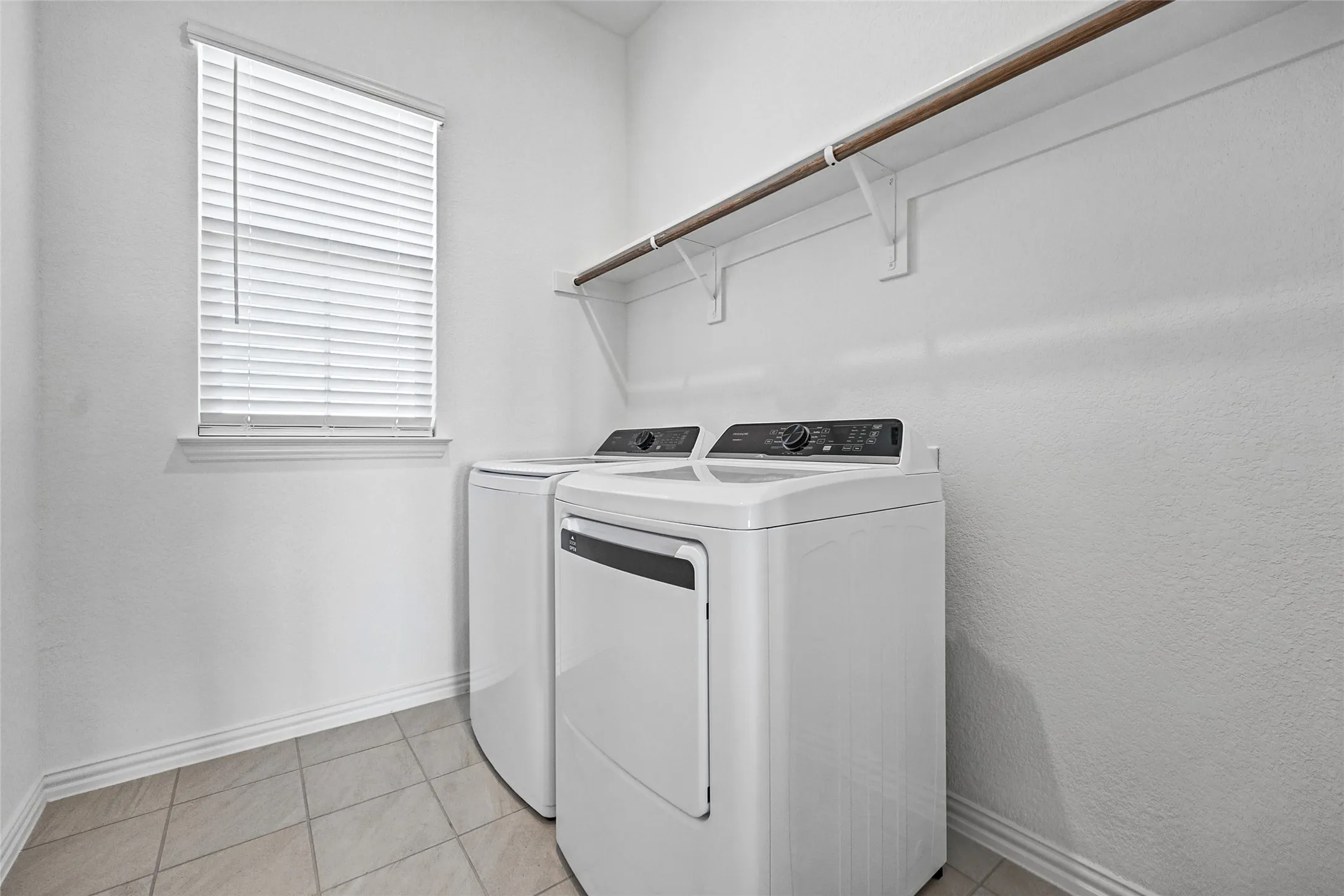Tiled flooring, window with blinds, wall-mounted shelving, and hanging rod