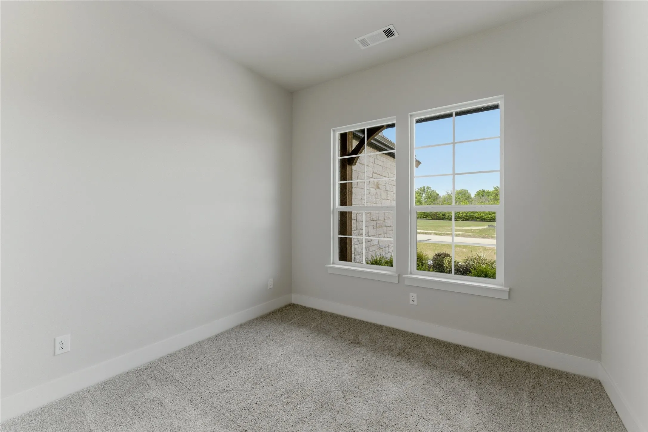 Empty room with light carpet and baseboards