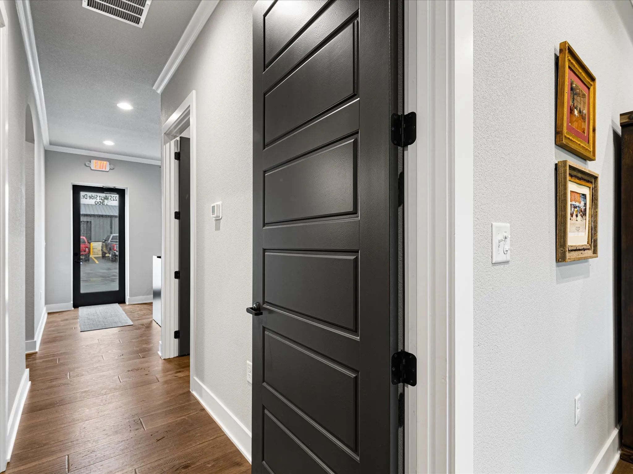 Corridor with ornamental molding, dark wood-type flooring, recessed lighting, and a textured wall