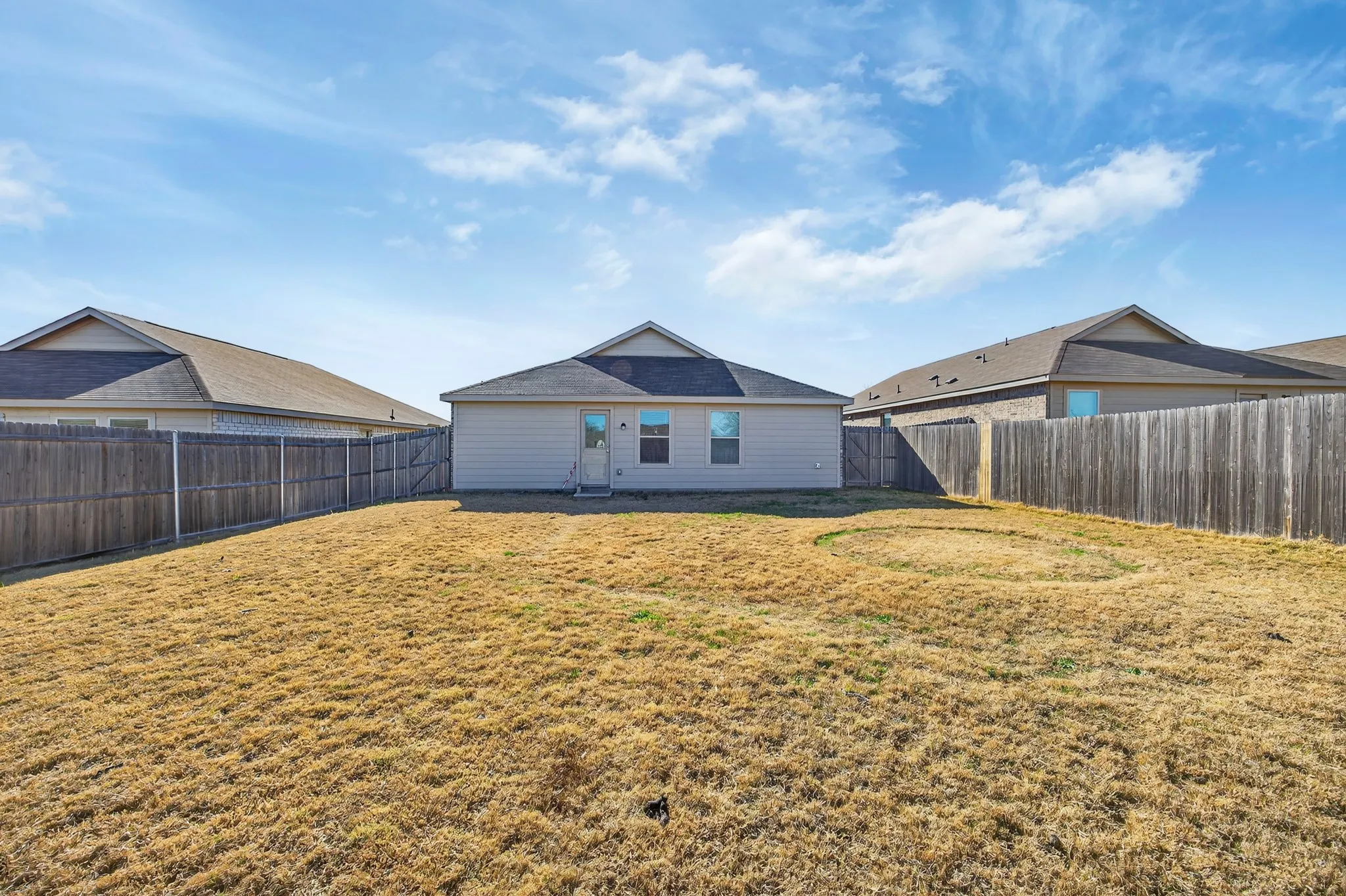Back of house with a fenced backyard