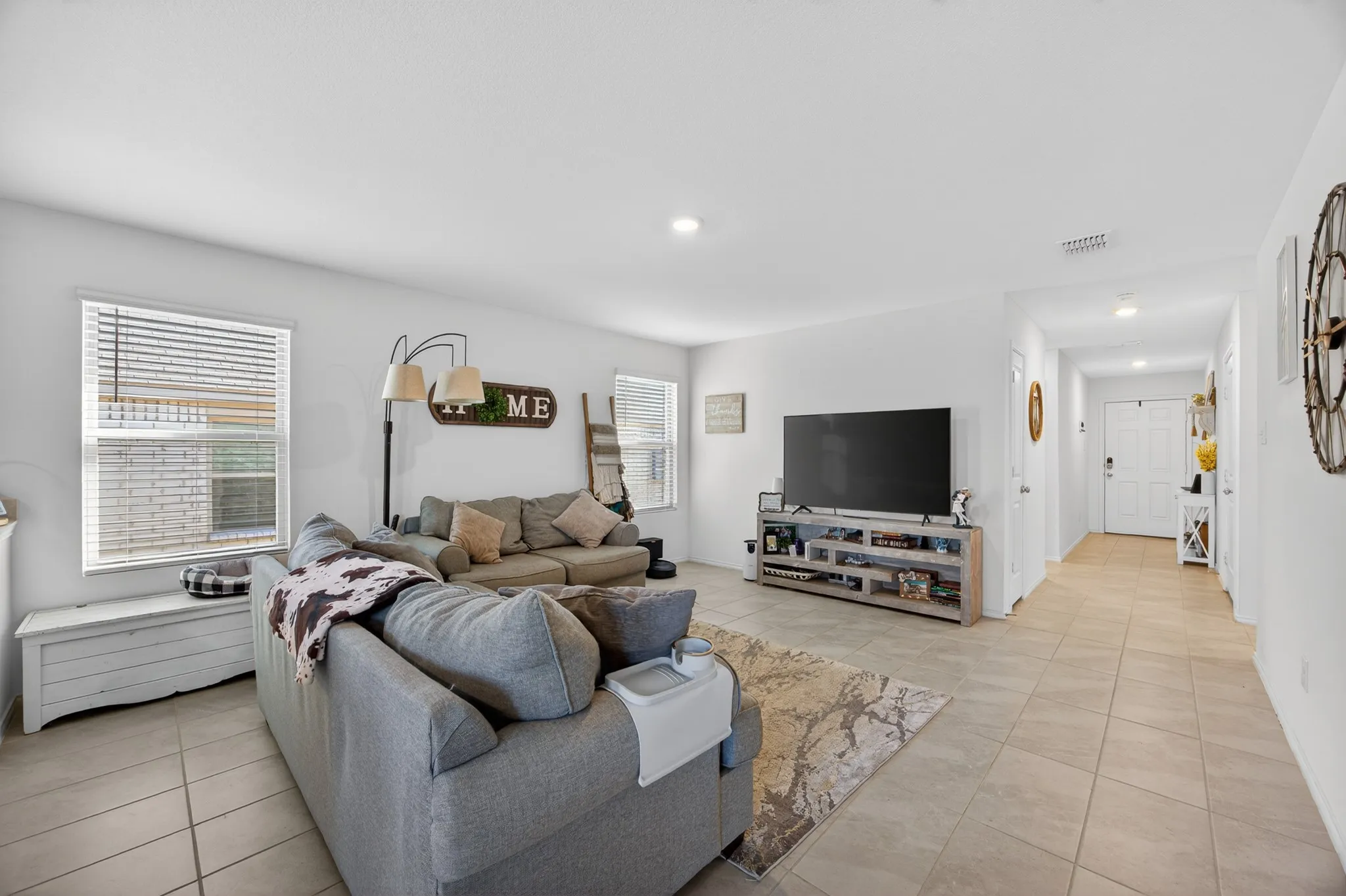 Living room with light tile patterned flooring and recessed lighting