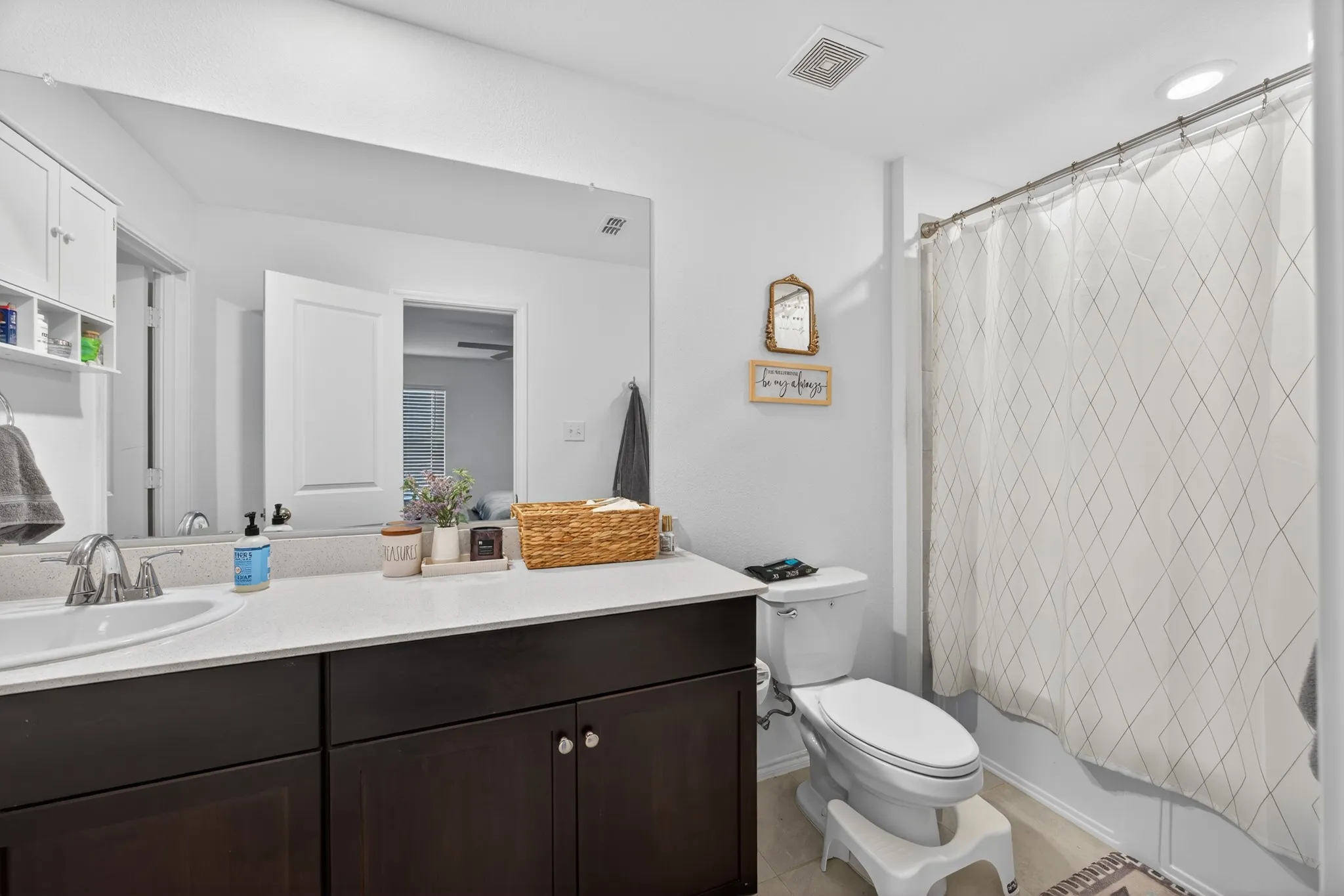 Bathroom featuring vanity and shower / bathtub combination with curtain