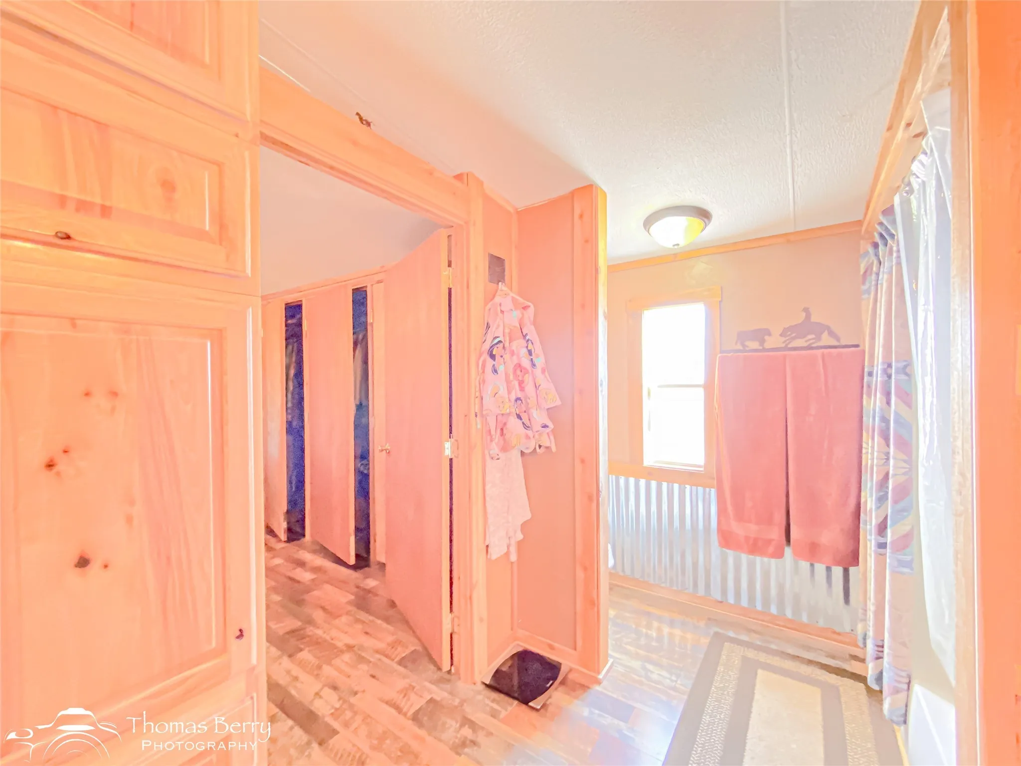 Hall with a textured ceiling and light wood finished floors