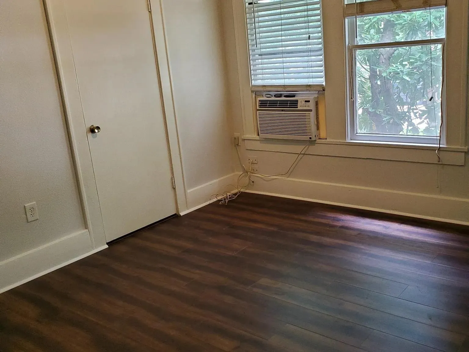 Unfurnished room with dark wood finished floors and cooling unit