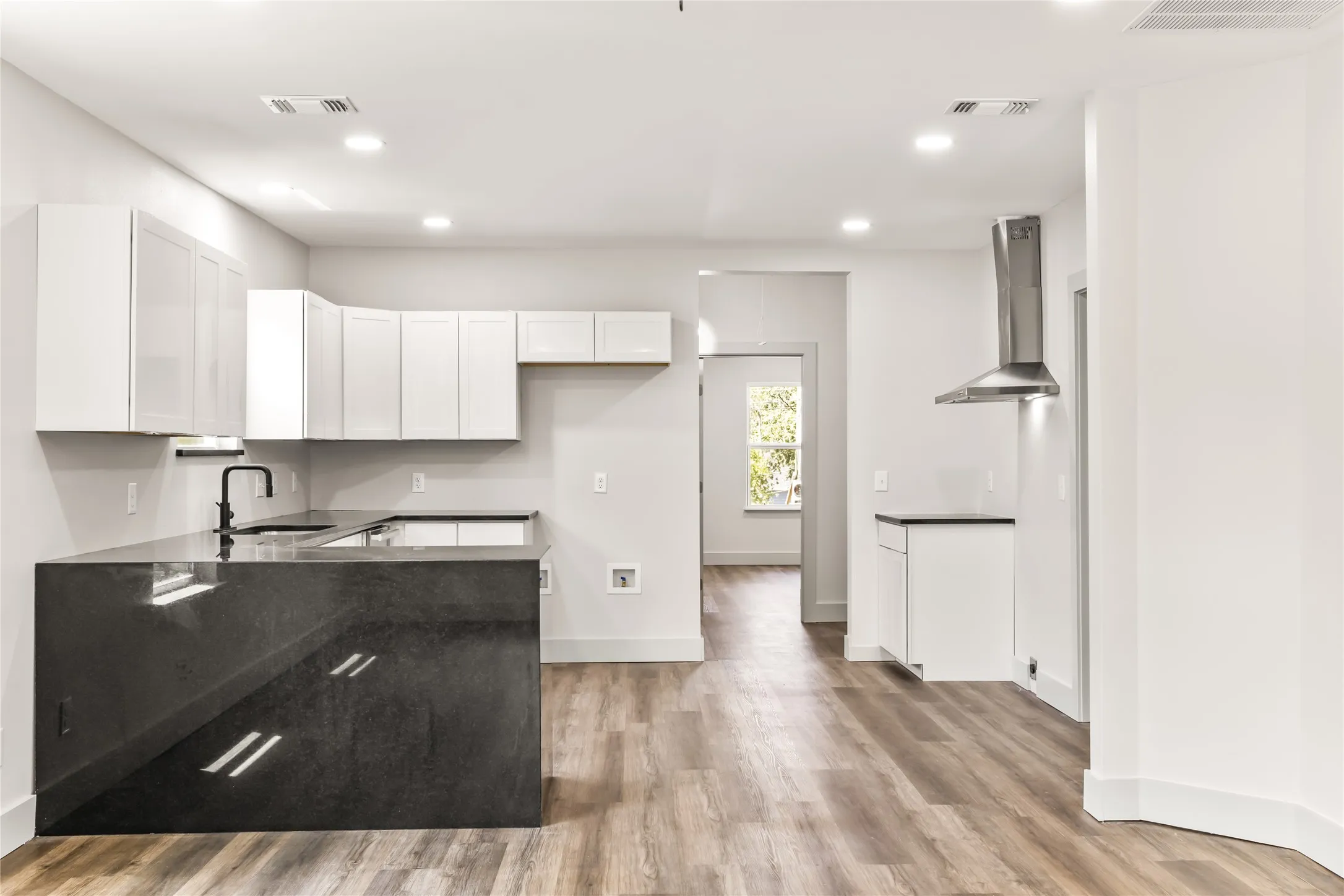 The kitchen area extends across the to the stov area with a nice stainless steel vent.  (Stove is coming.)