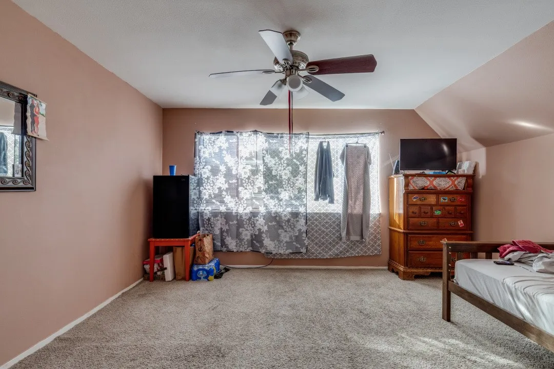 Bedroom with ceiling fan and bright window
