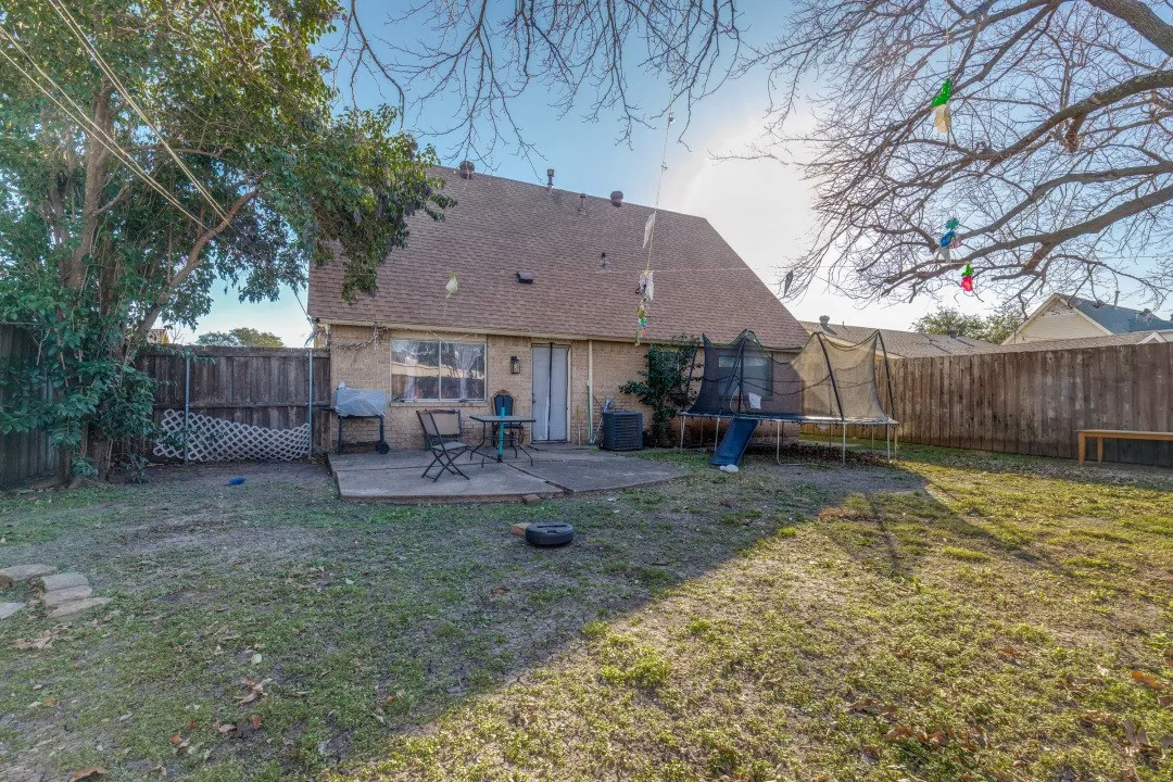 Rear exterior with covered patio and privacy-fenced yard