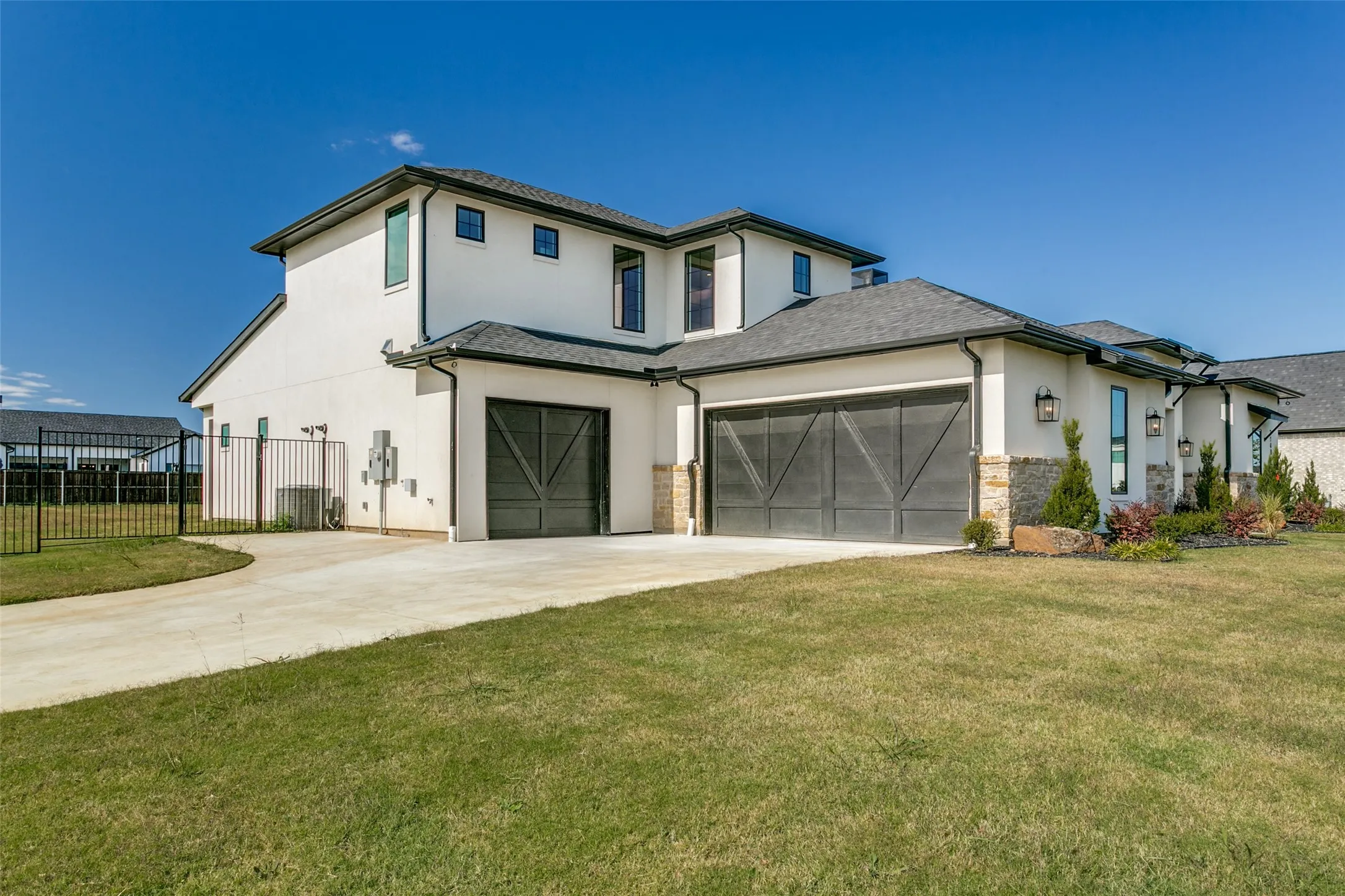 View of front of house featuring stucco siding, driveway, stone siding, and an attached garage